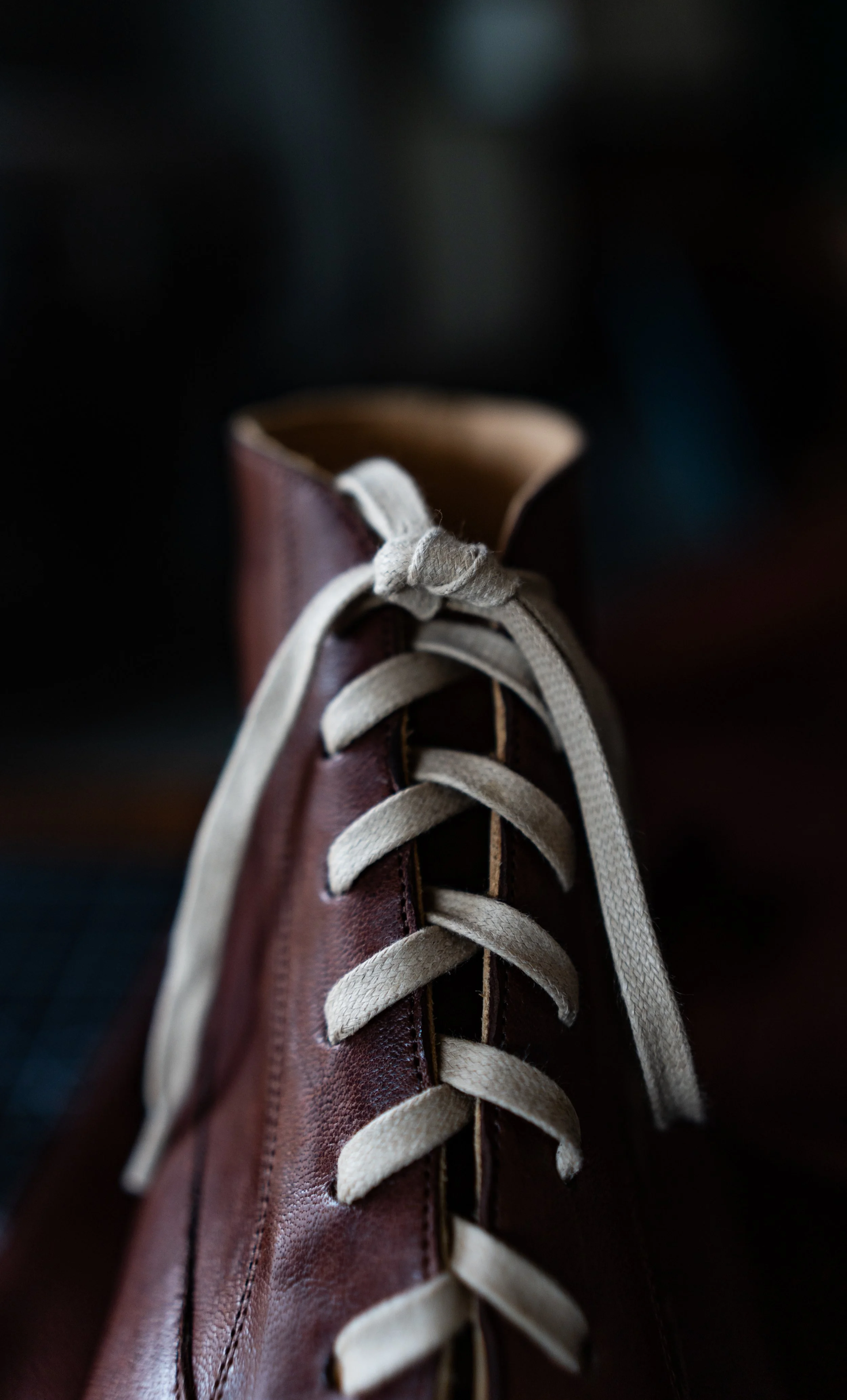 Close-up of a brown leather shoe with beige laces.