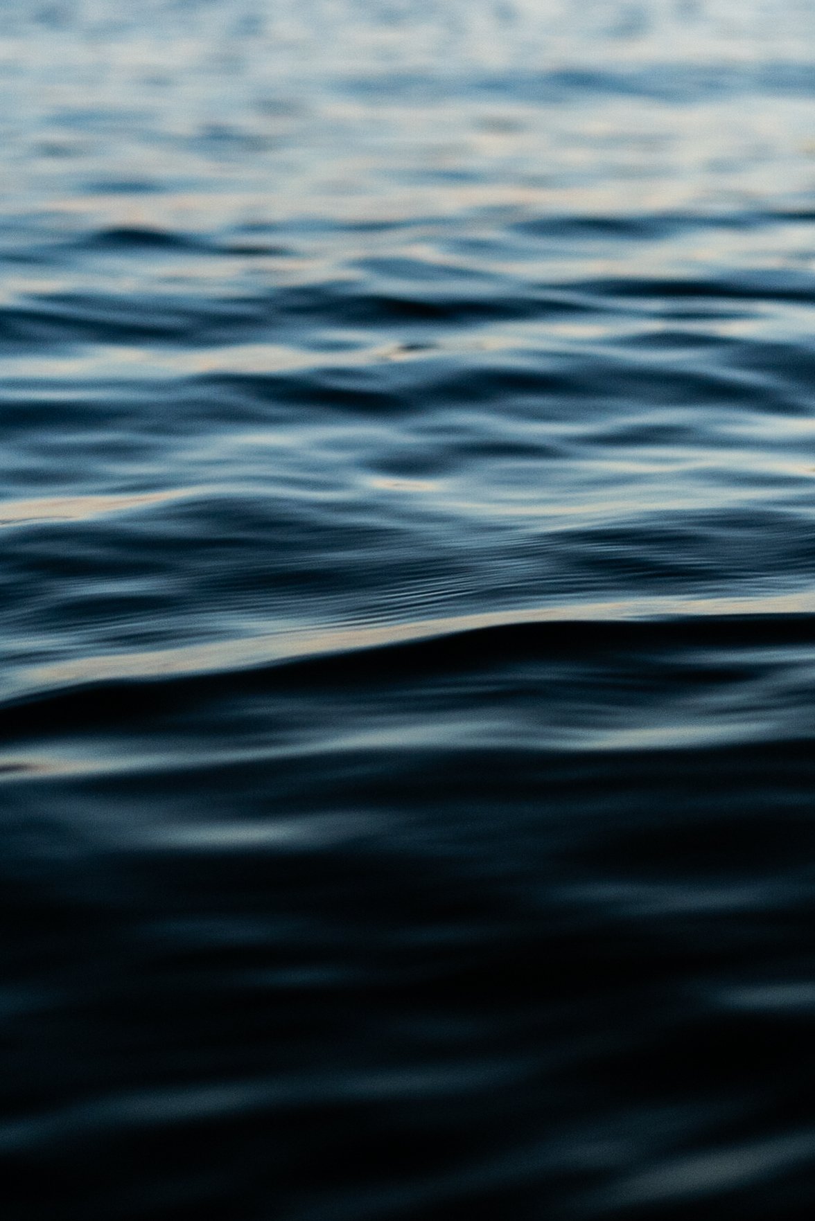 A calm body of water with gentle ripples and a slightly darker horizon in the distance.