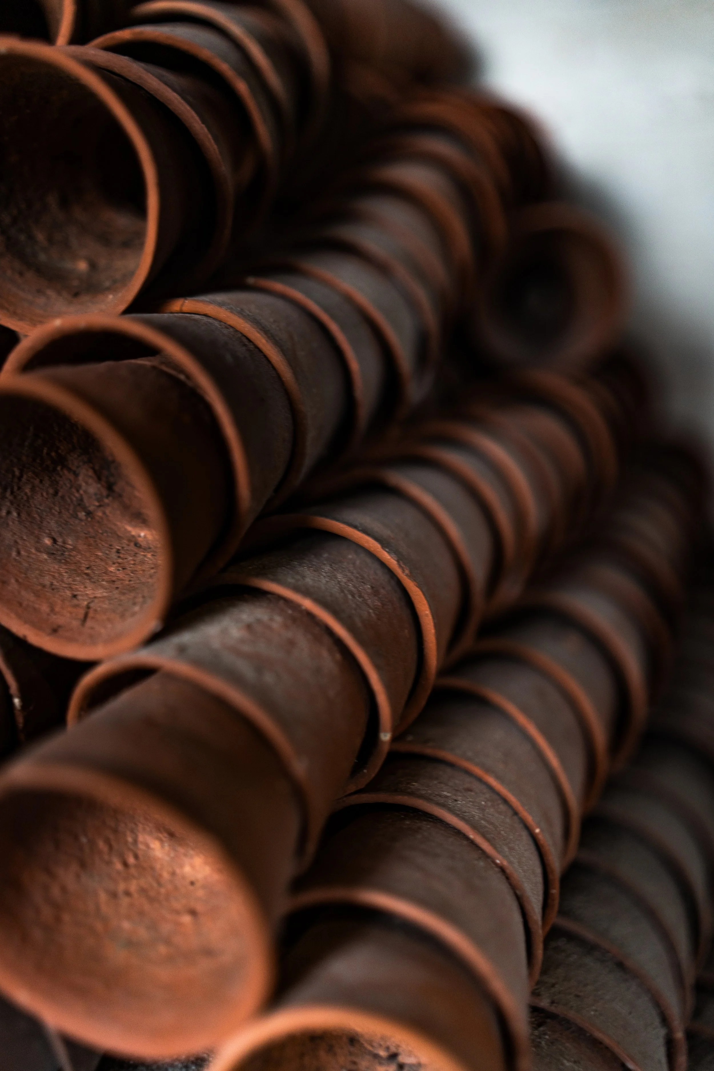 Stack of rusty metal pipes arranged in parallel, with a close-up view.