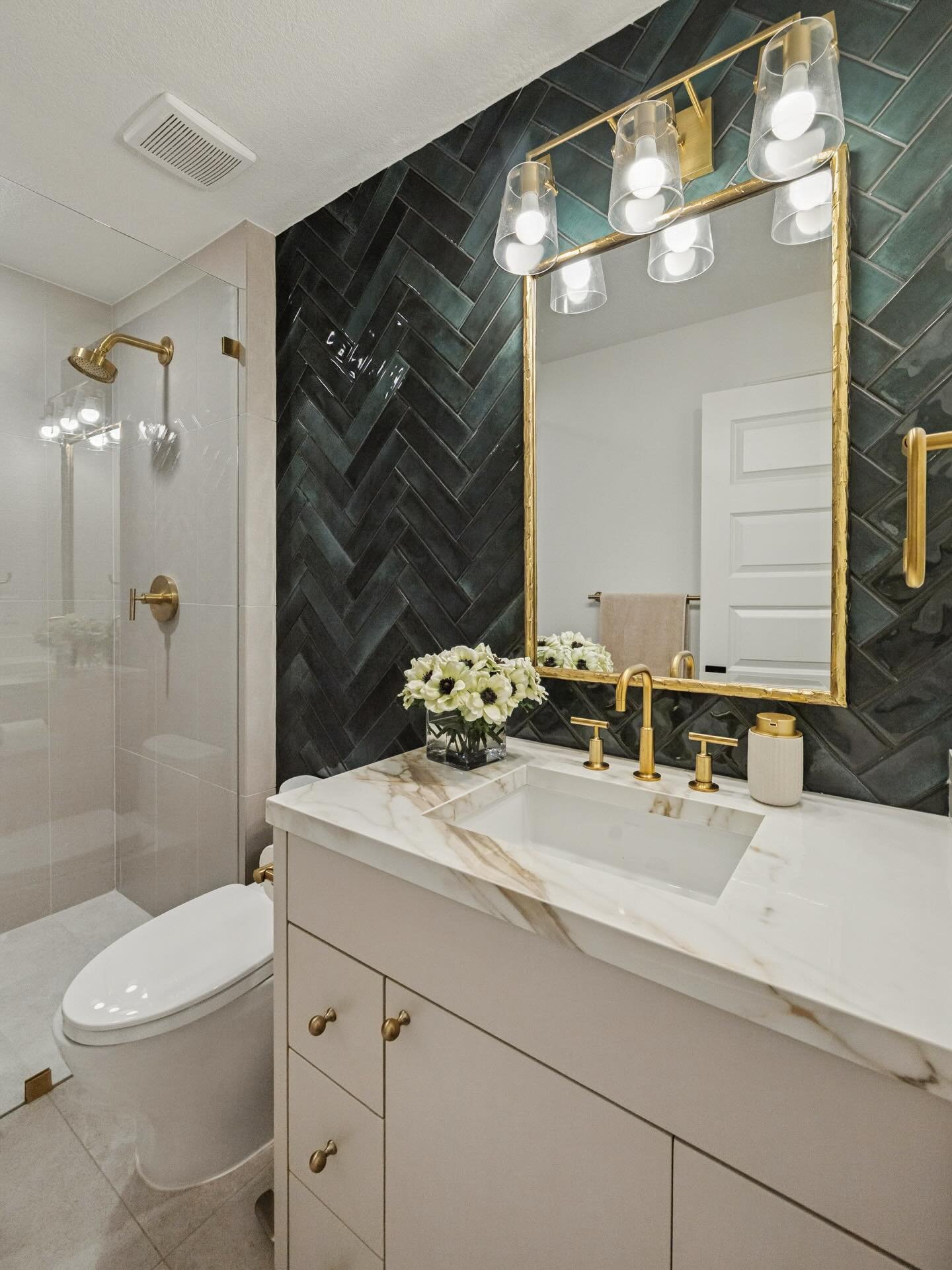 Builder-grade ➡️ designer-grade (aka the glow up this bathroom deserved).

We took a basic bath and turned it into a moment &mdash; bold accent tile bringing the drama, warm brass finishes adding instant luxury, and a Calcutta Gold countertop tying i