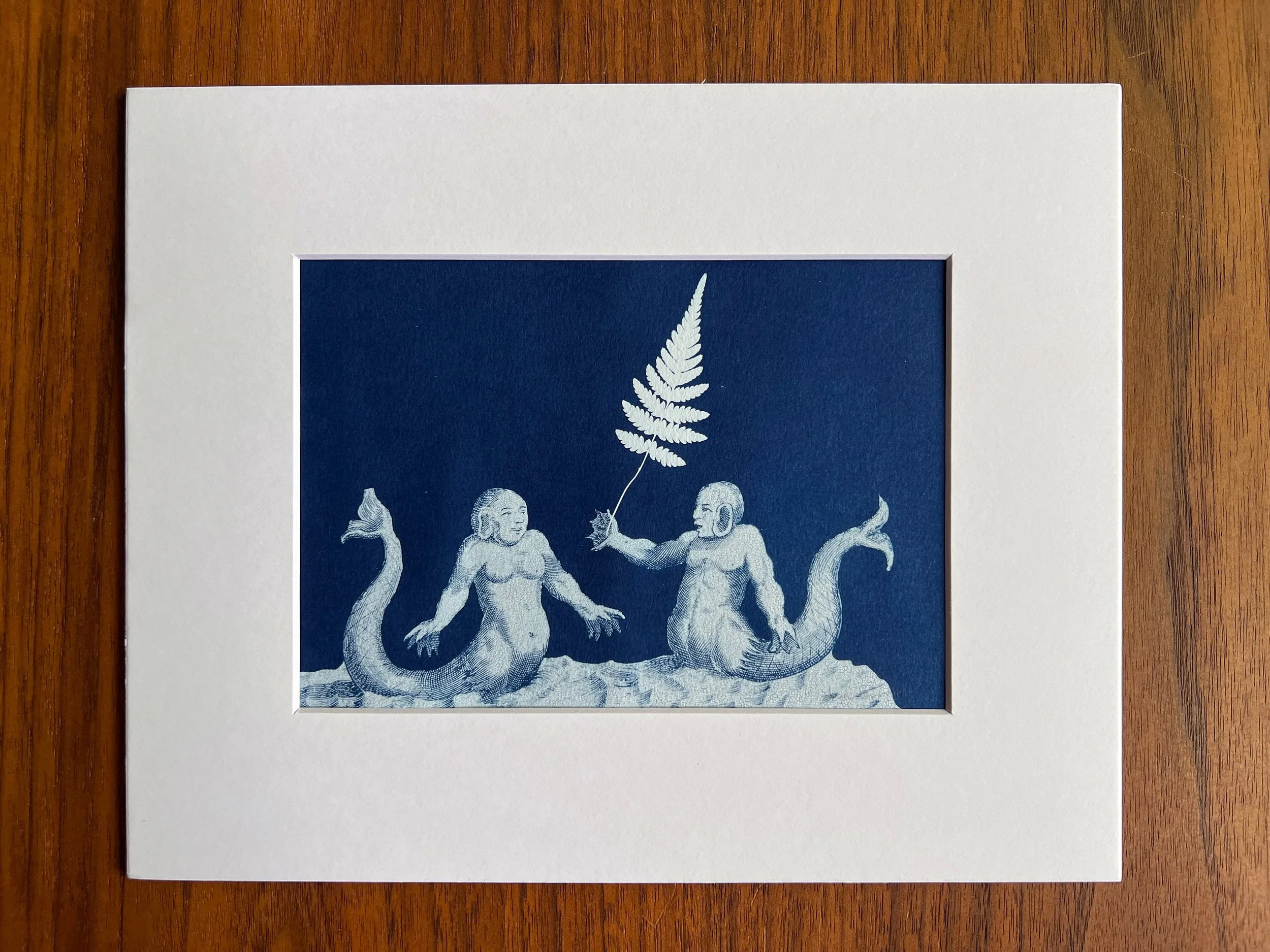 This is an original cyanotype featuring the courting rituals of mermaids and mermen (or some other sea-beings?)