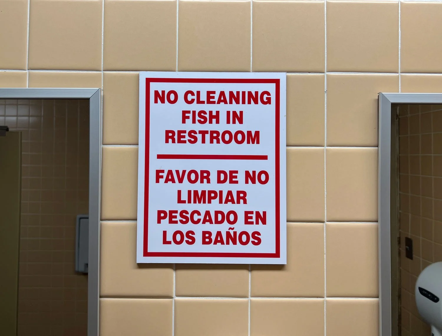 A sign in a public bathroom reads "no cleaning fish in the restroom"