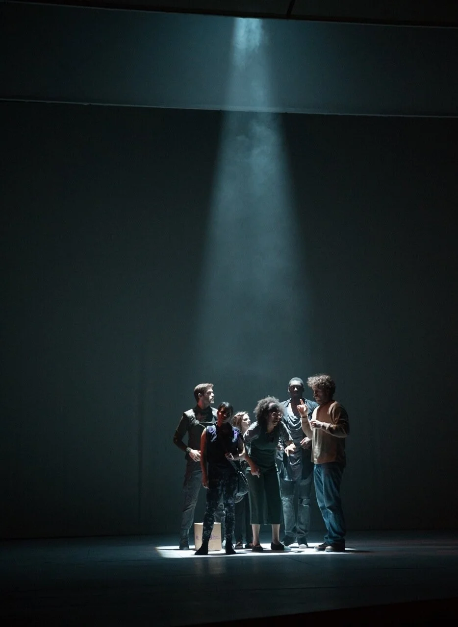 Light shining on a group of actors in a darks space