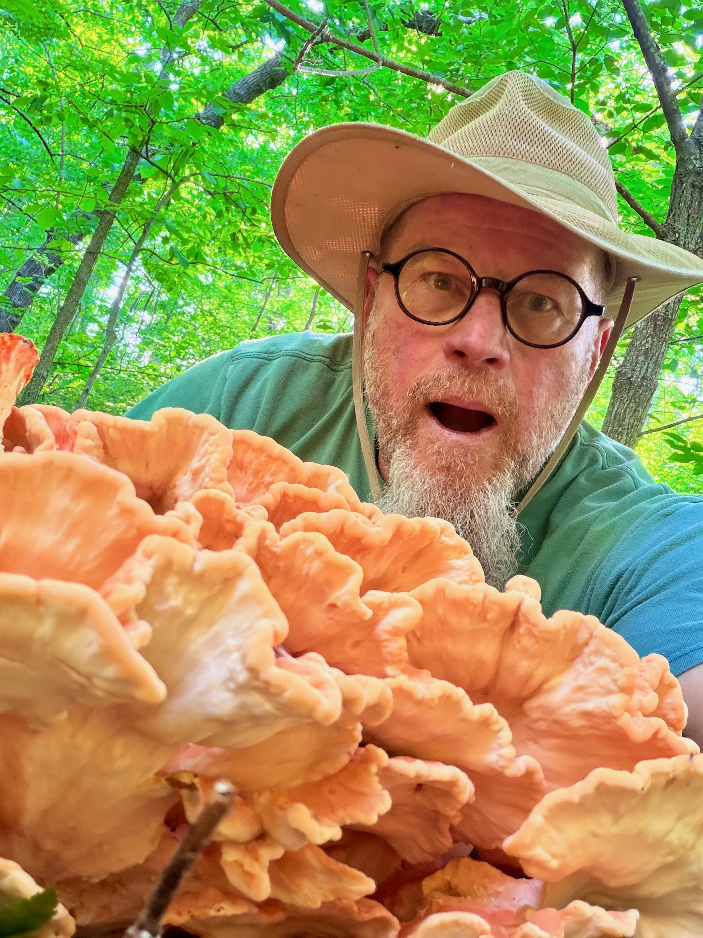 Picture of Paul Rudy amazed at a 10 pound bright orange checken of the woods mushroom.