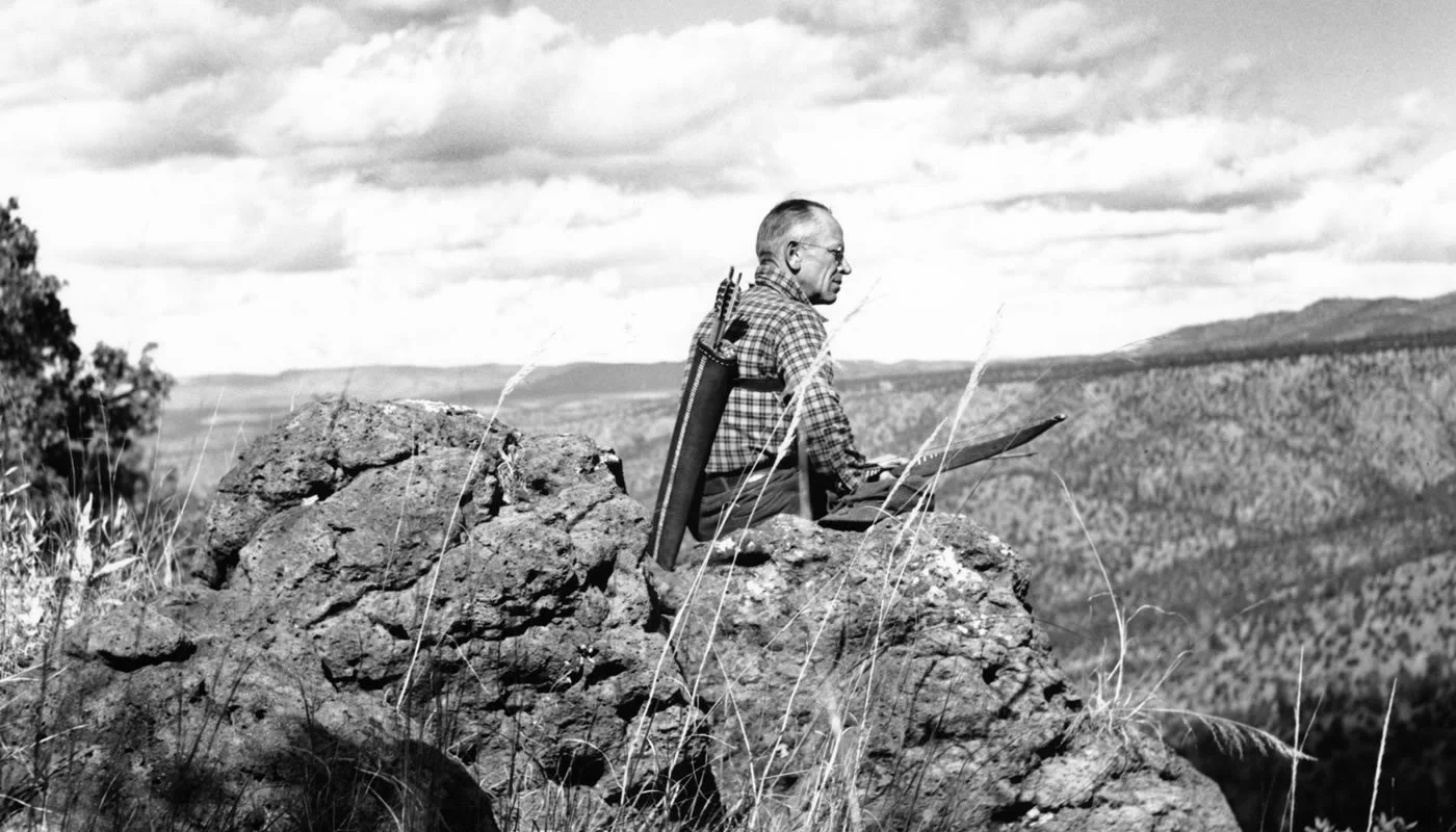 Aldo Leopold staring out from an outcrop of rocks