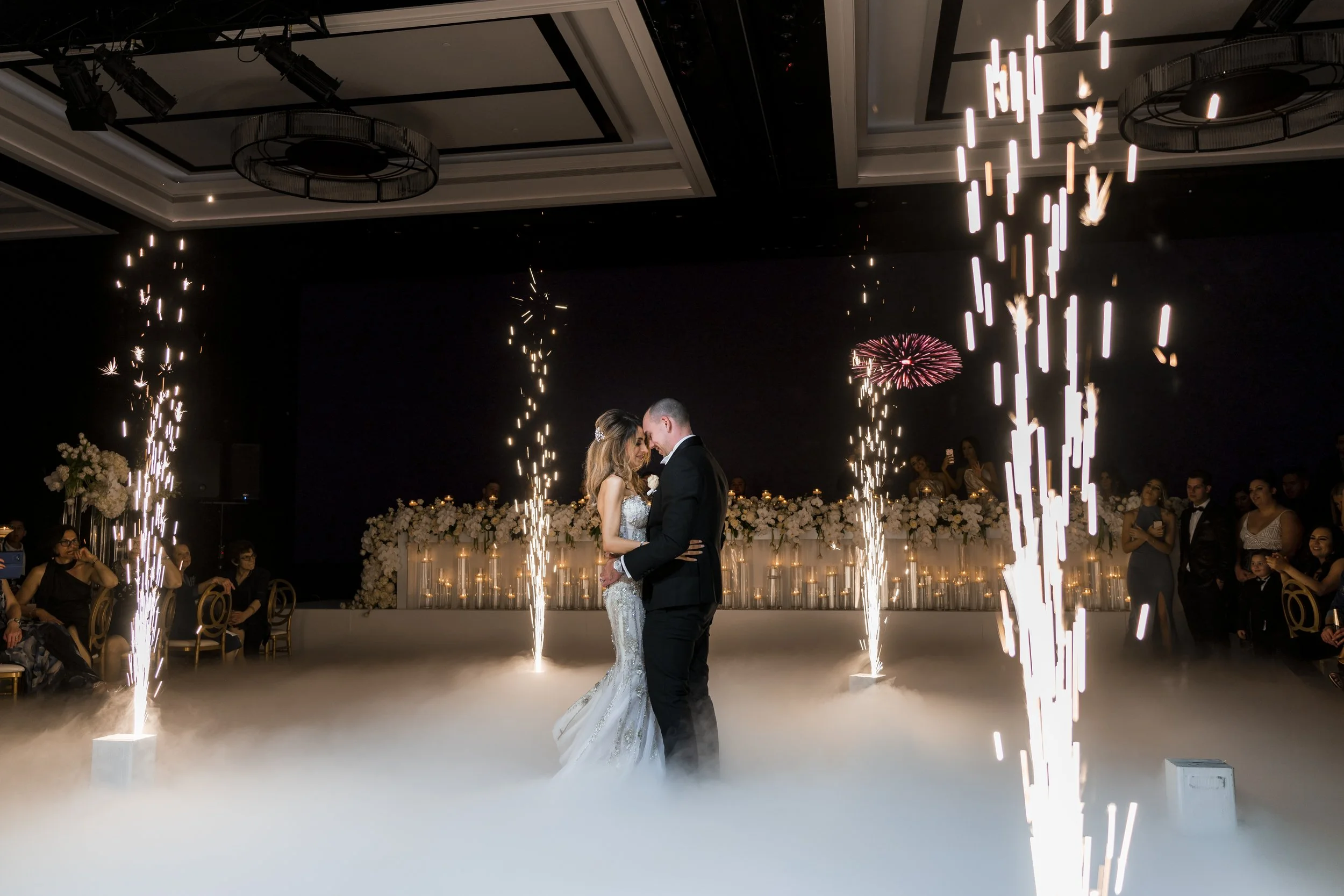 Bride and groom share their first dance with smoke and fireworks