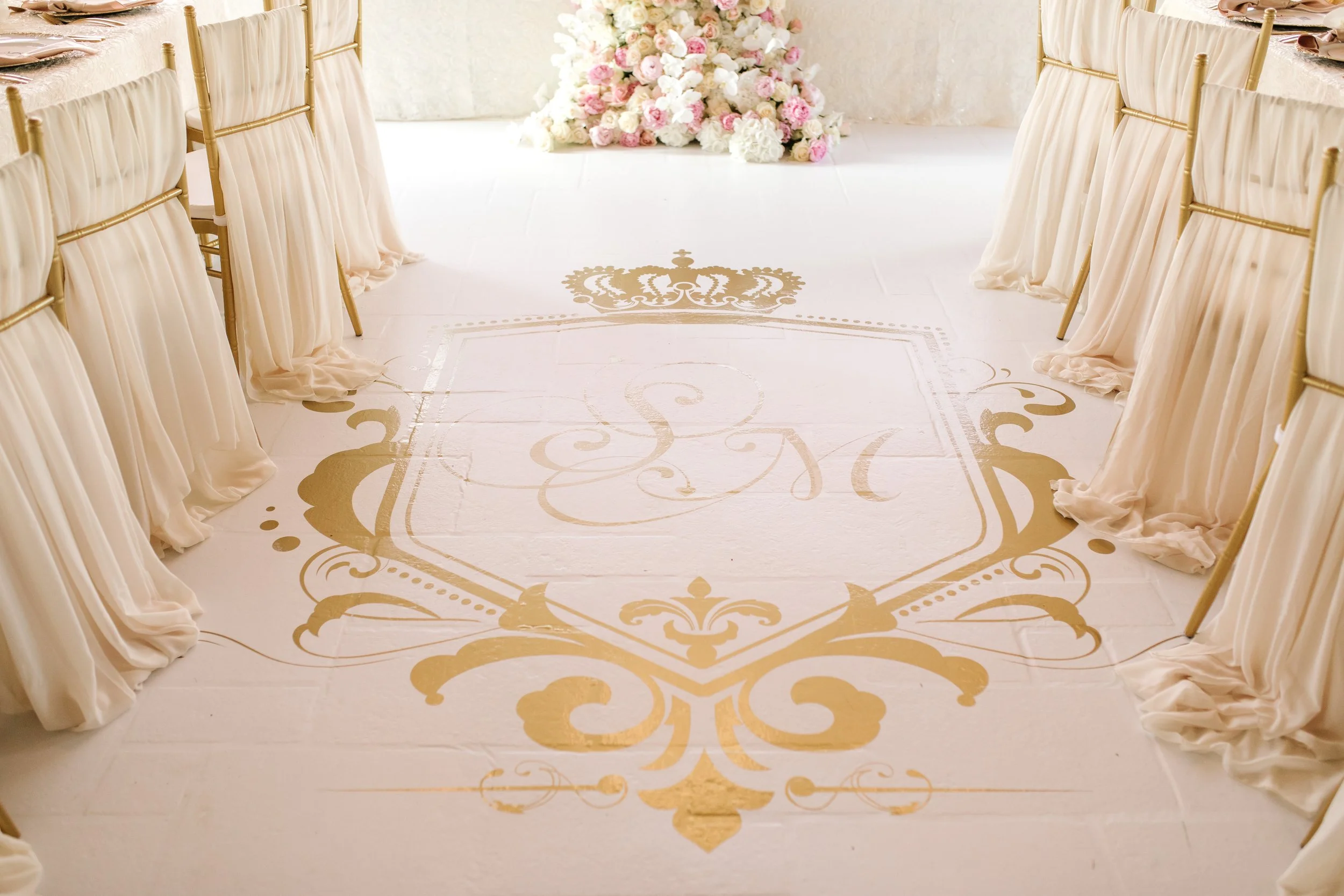 White gloss flooring with a gold decal for the wedding reception.