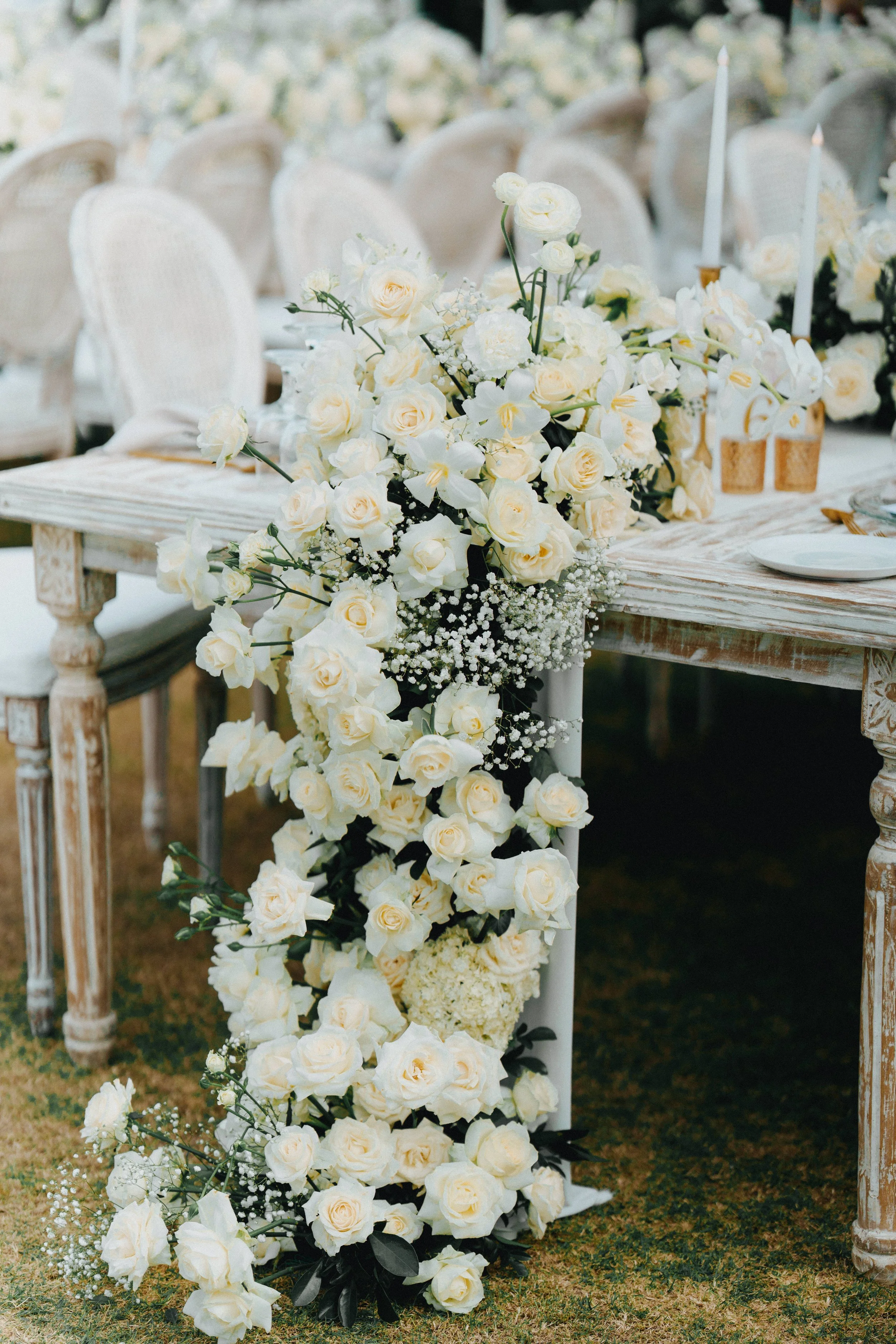 Cascading white florals styled on the side of the wedding guest tables