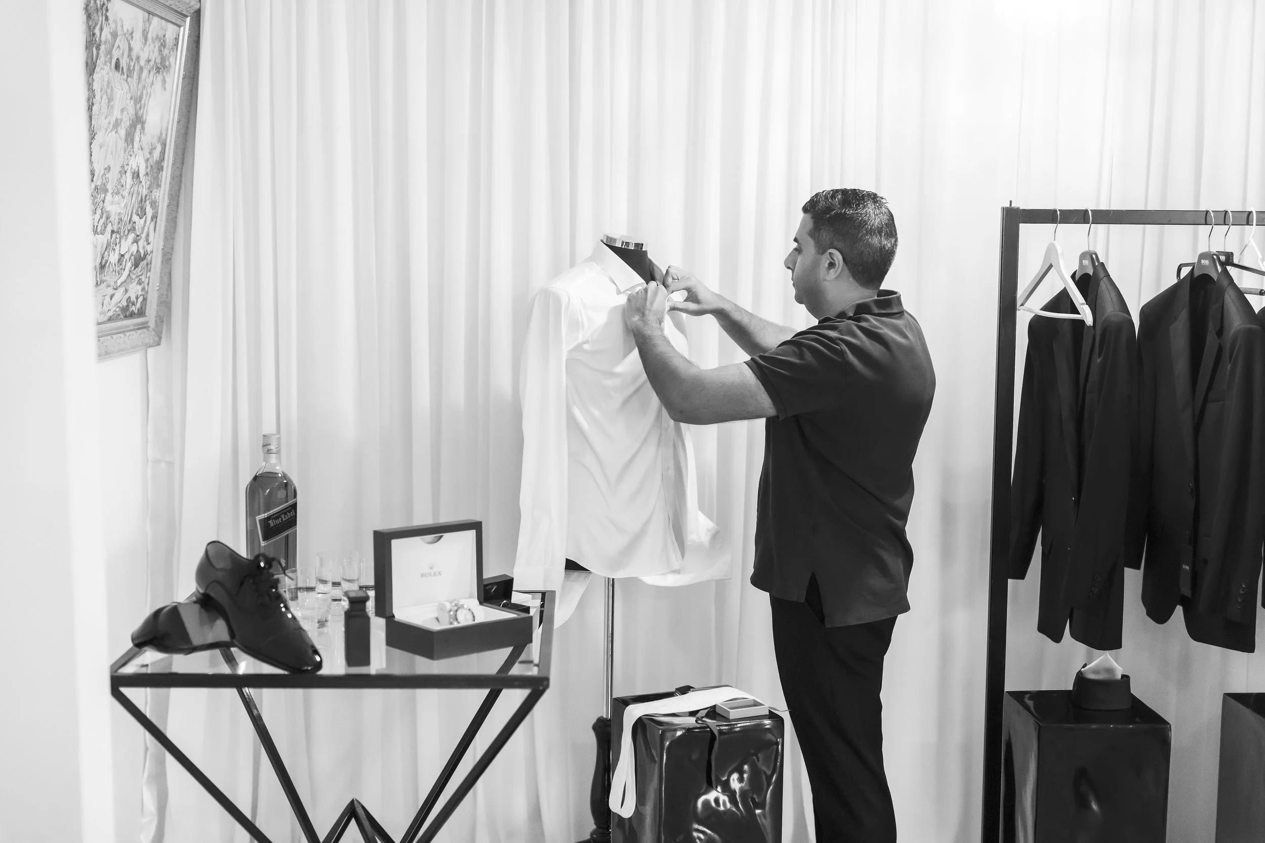 Groom getting ready the morning of the wedding in a masculine  styled room