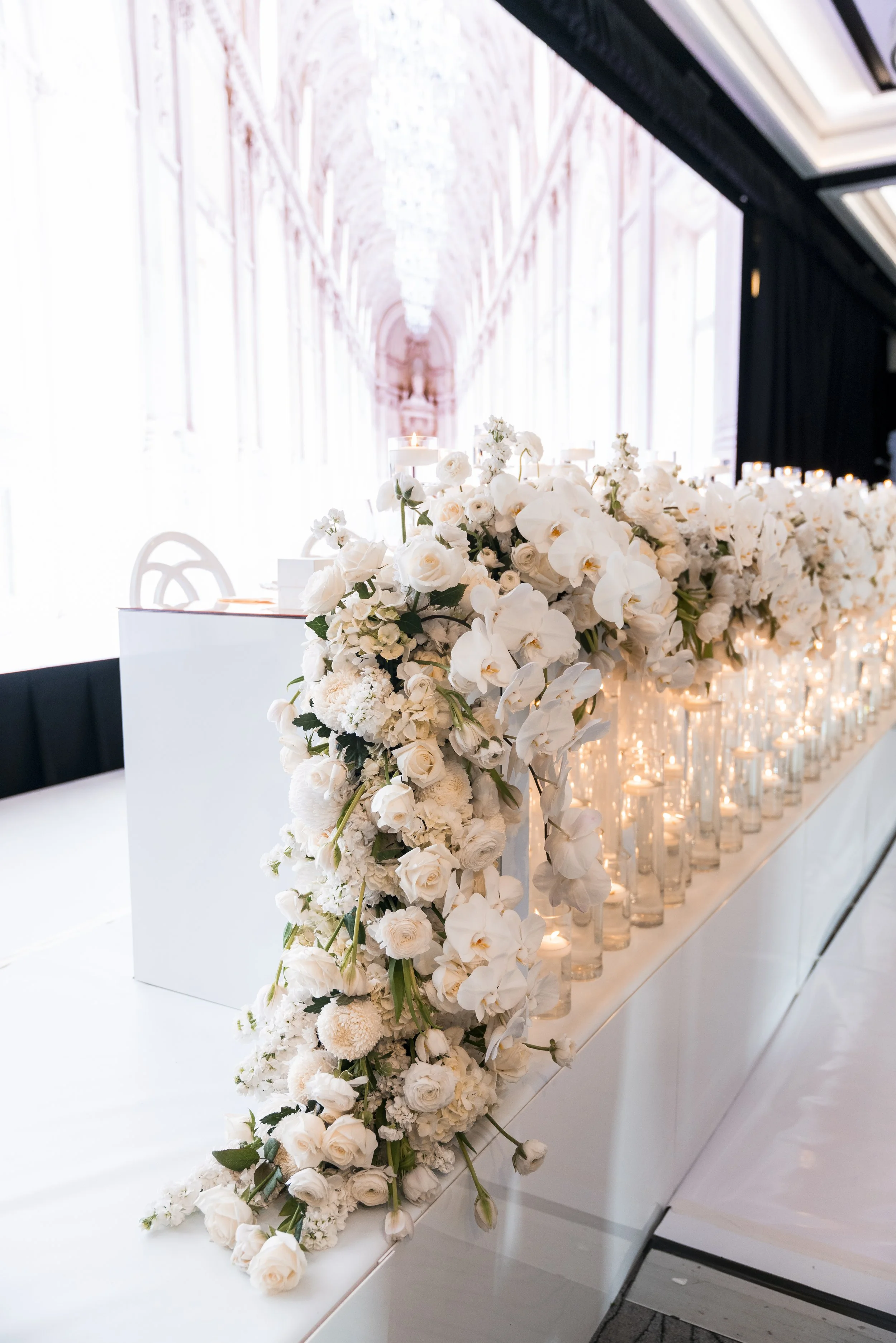 Dramatic flowers styled on the bridal stable with an LED screen backdrop