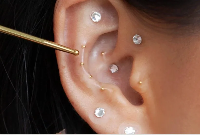 24k and swarovski ear seeds on a woman's ear