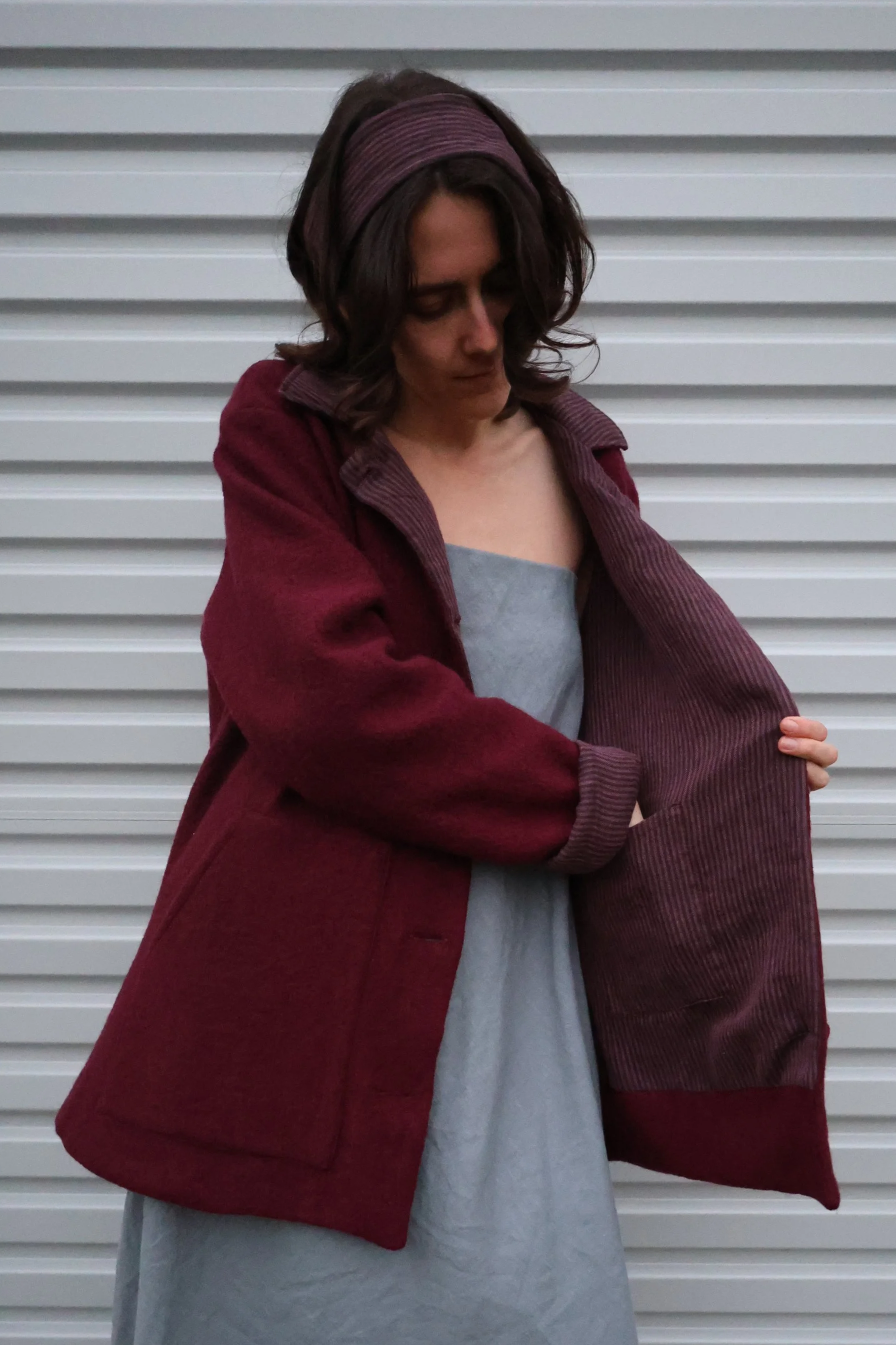 A woman reaching into a hidden pocket in the lining of a fully lined wool coat.