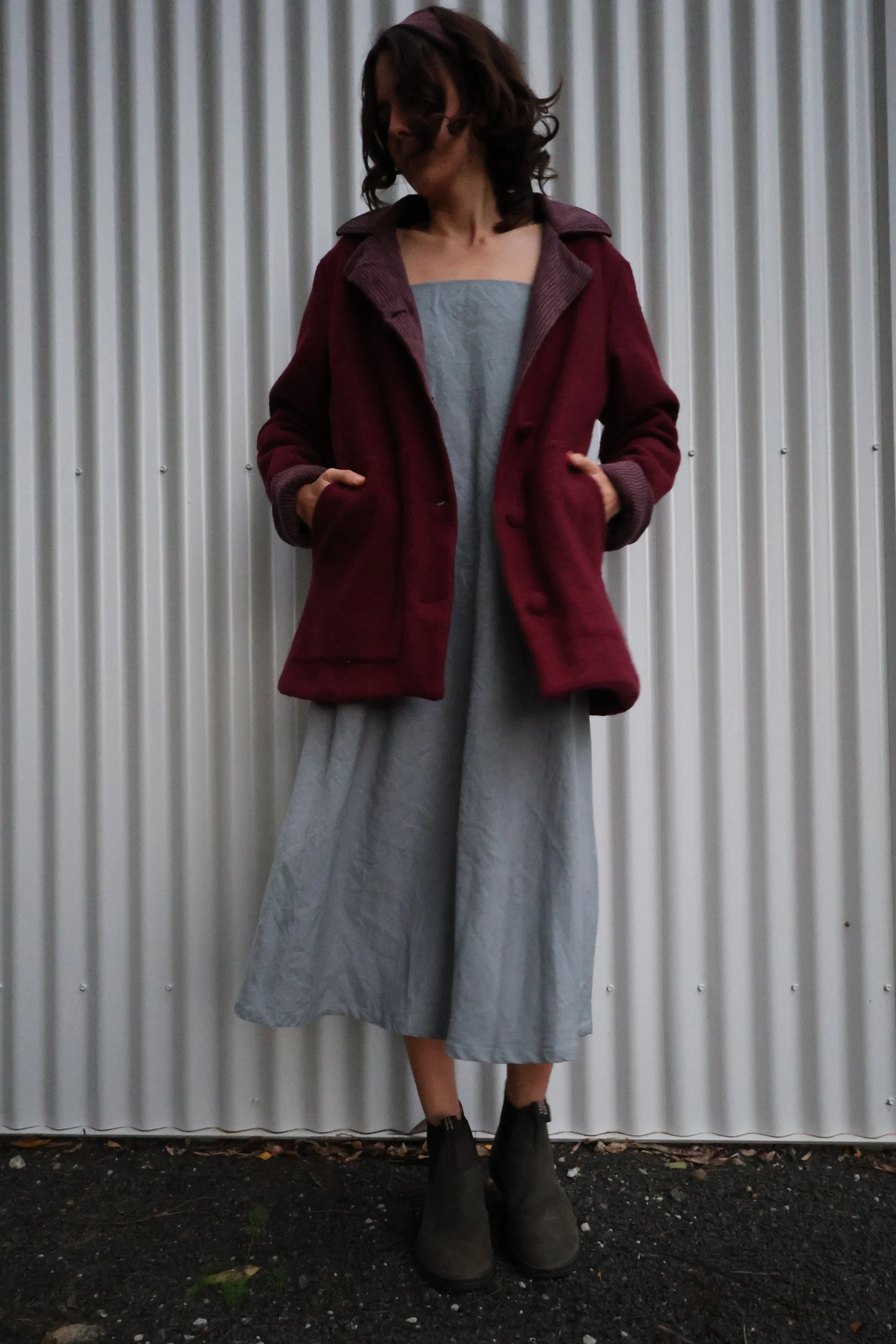 A women in a wool coat with her hands in its deep pockets