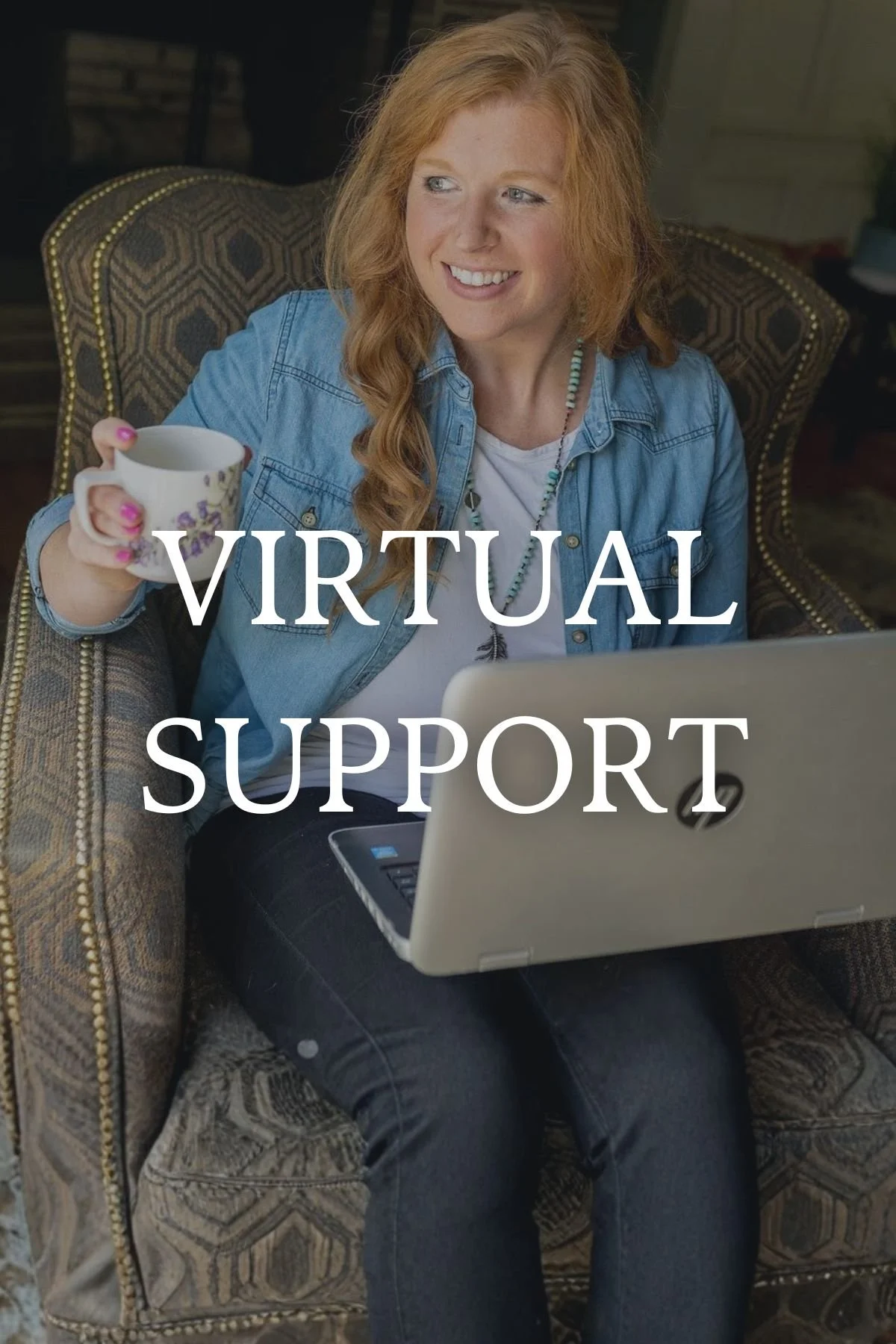 A woman with red hair smiling while sitting on an upholstered armchair, holding a mug, using a laptop, with the text 'VIRTUAL SUPPORT' overlaid.