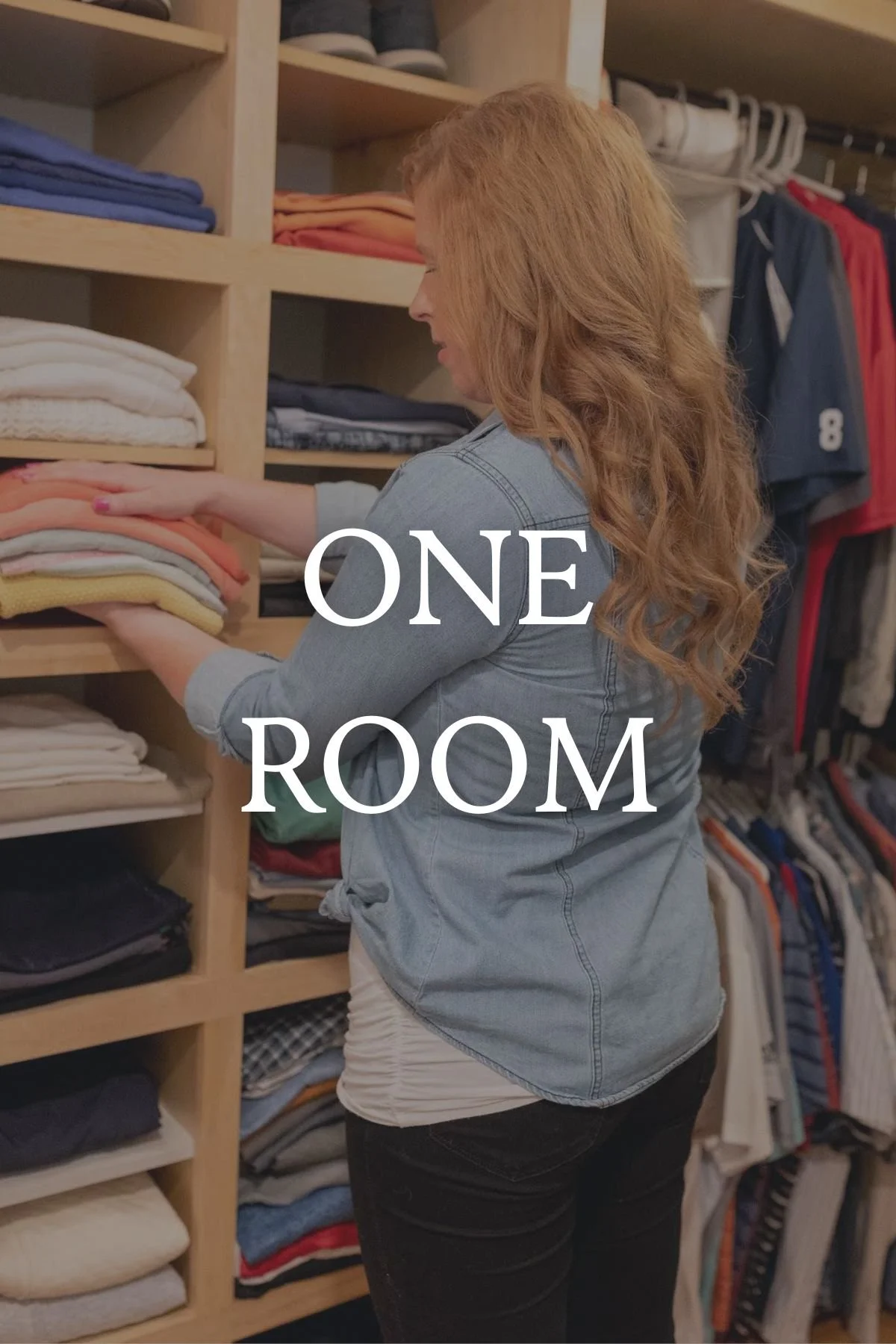 A woman with long, curly red hair looking at folded clothes on shelves in a closet or store, wearing a denim jacket and black pants, with hanging clothes in the background. The text on the image says 'One Room.'
