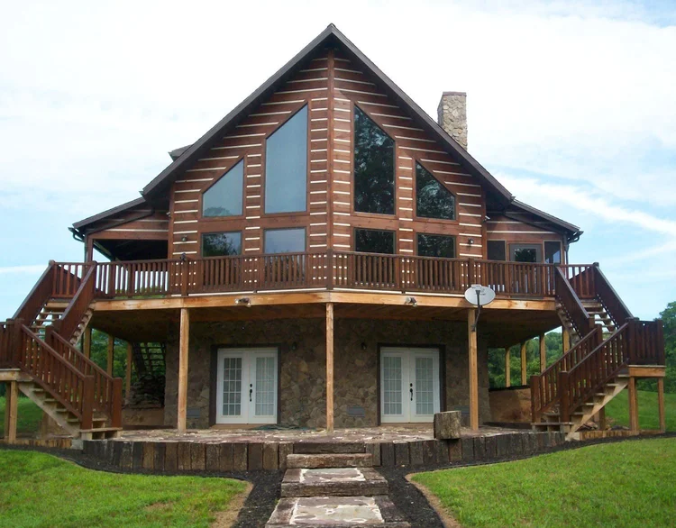 Conway log home side view with natural landscaping