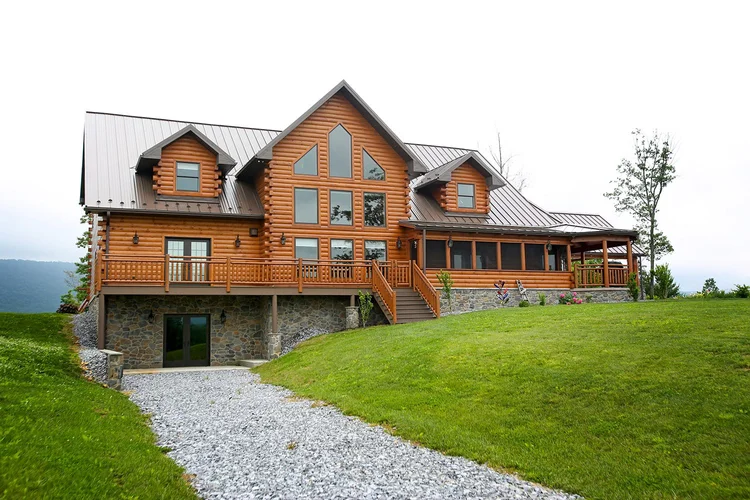 Custom log home with attached three-car garage by KSM