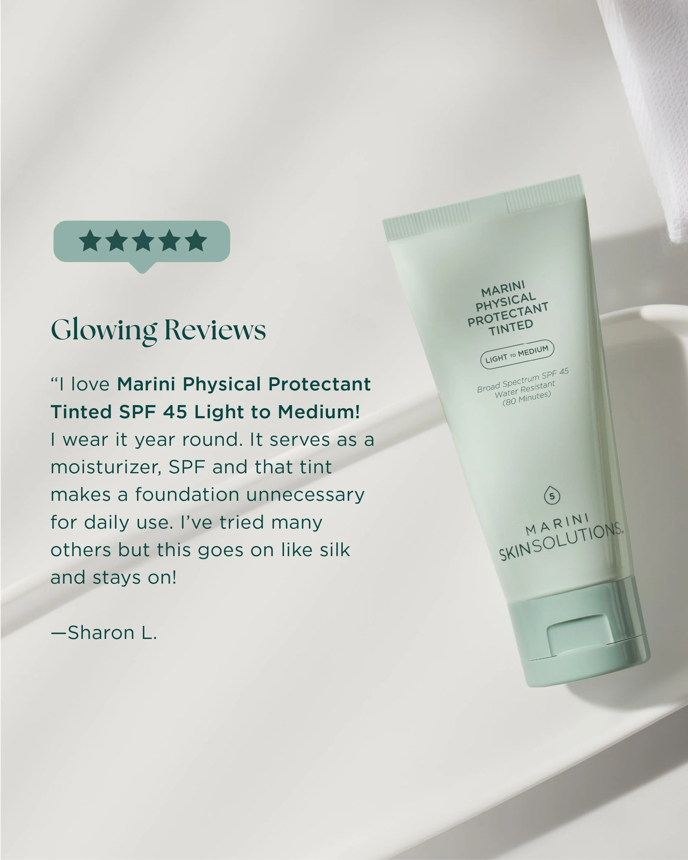 Close-up image of a tube of Marini Physical Protectant Tinted SPF 45, light to medium, on a white surface with a towel nearby and text advertising its features.