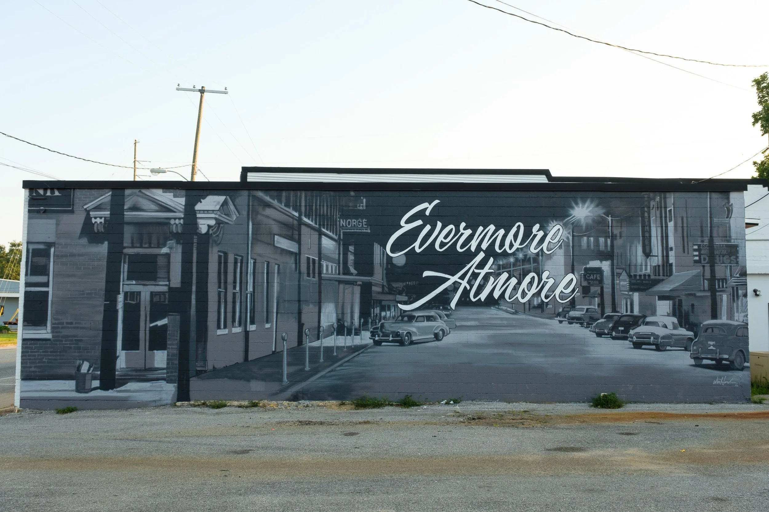 Mural that reads "Evermore Atmore" with historic downtown and classic cars in the backgound