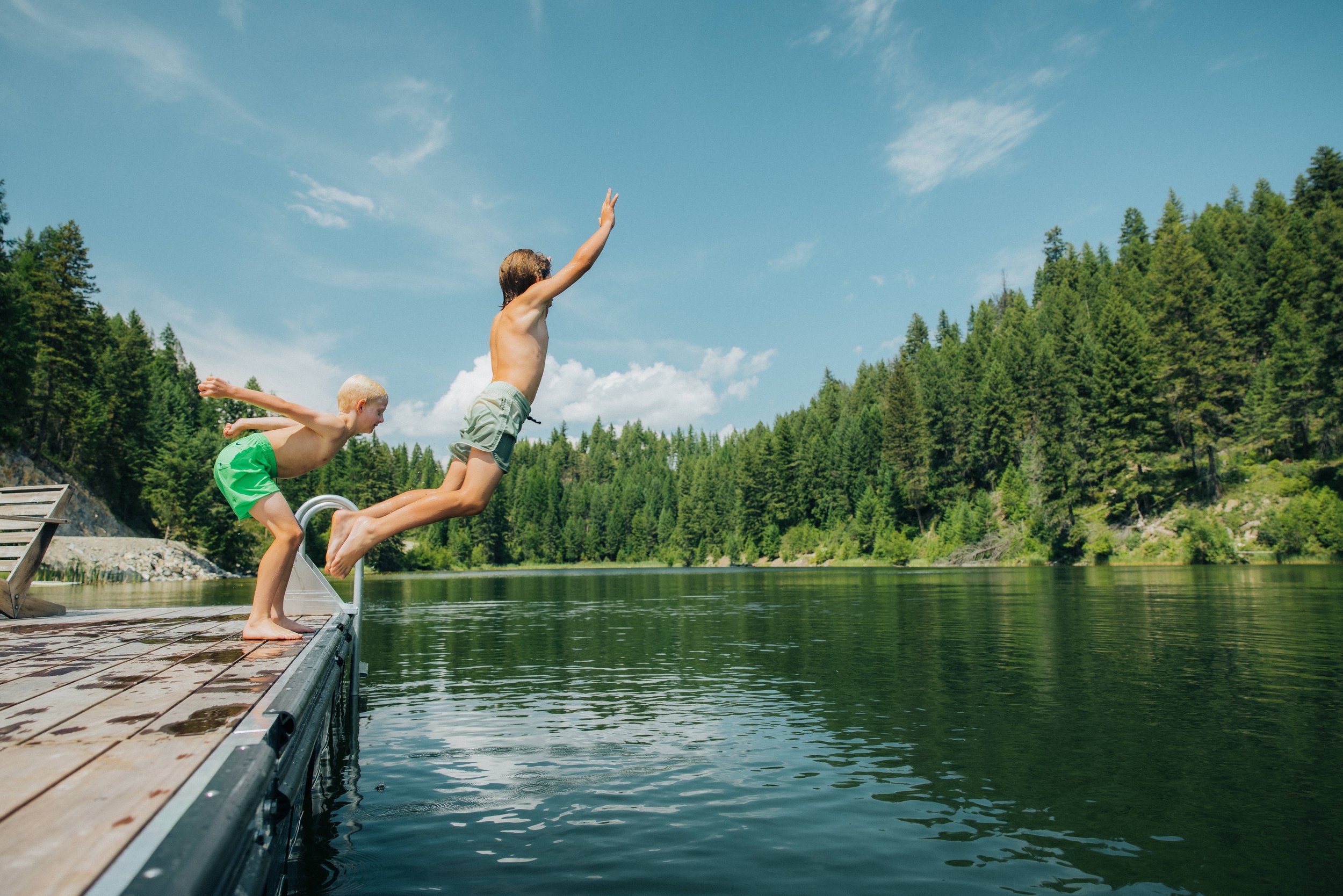 Kids jumping into the water at bootjack lake at the homestead whitefish montana