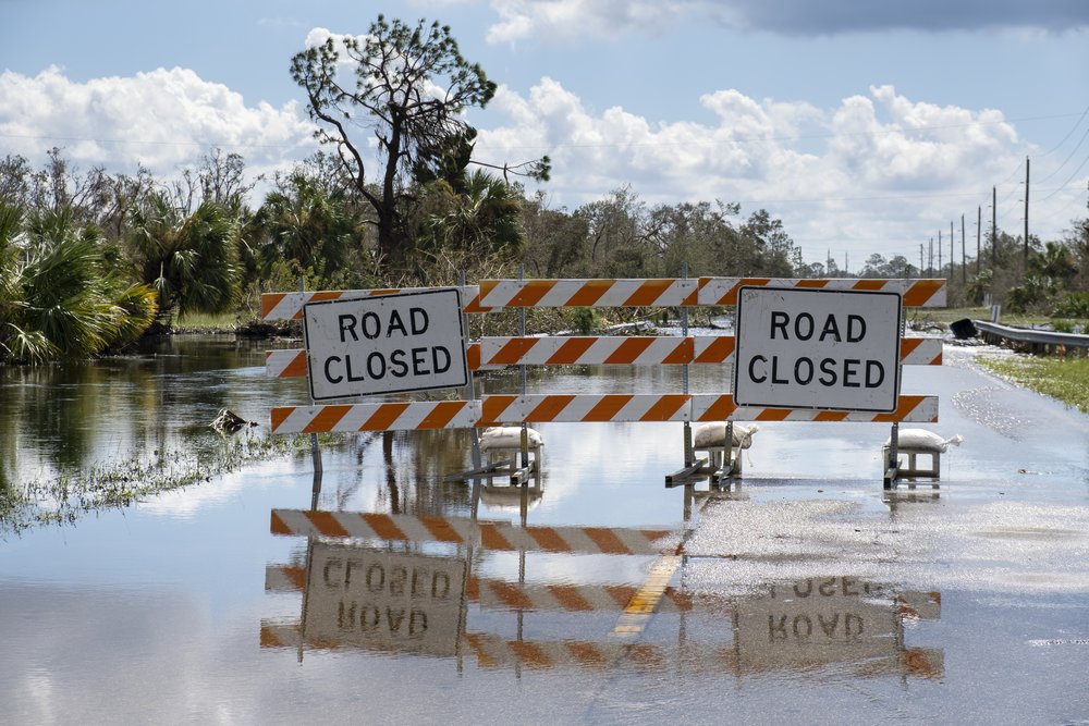 flooded-street-florida-after-hurricane-rainfall-with-road-closed-signs-blocking-driving-cars-safety-transportation-natural-disaster-concept (1).jpg