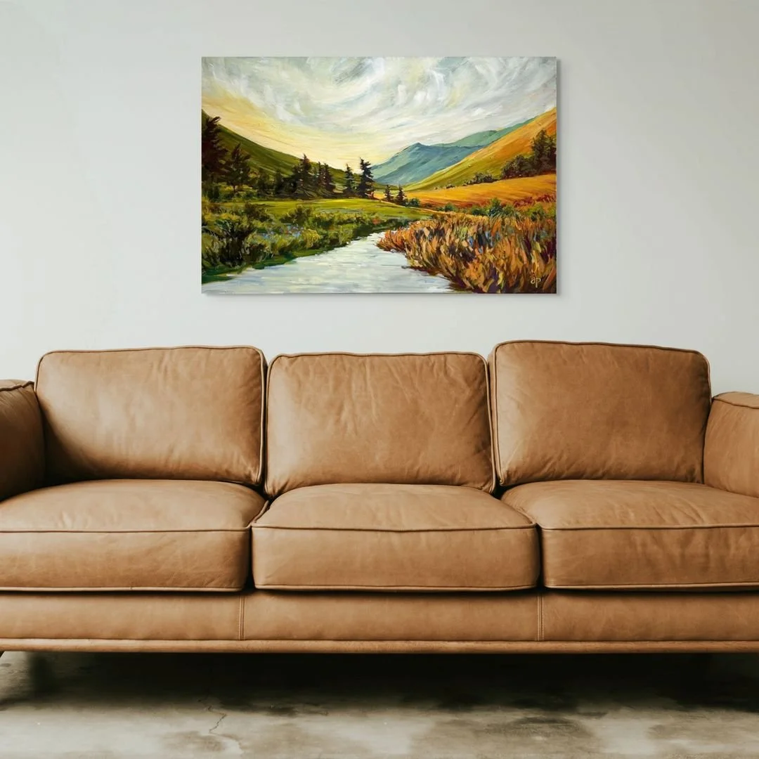 In a calming palette of greens, yellows and blues, the new version of “Horizon” marries the up-close texture of free-flowing grasses in the foreground with gently folding blankets of fields and mountains in the background. The river in th