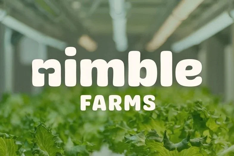 Nimble Farms logo in front of growing lettuce in a hydroponic container farm operation. Nimble is the partner that we have selected for our container farm at Black Water Acres.