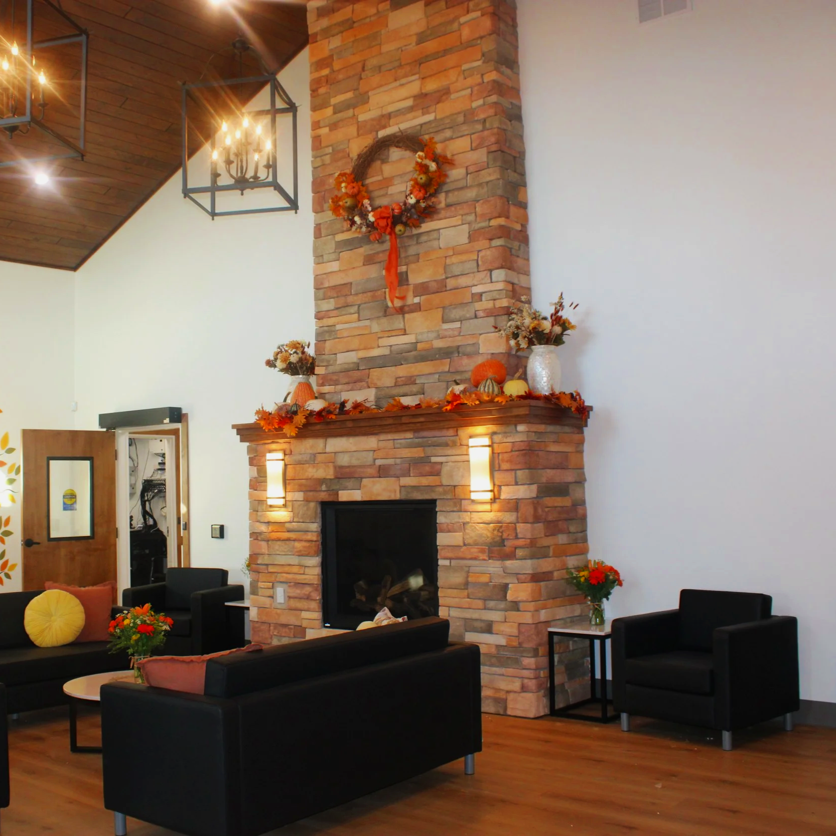 Front lobby with gas fireplace and leather furniture decorated with fall items