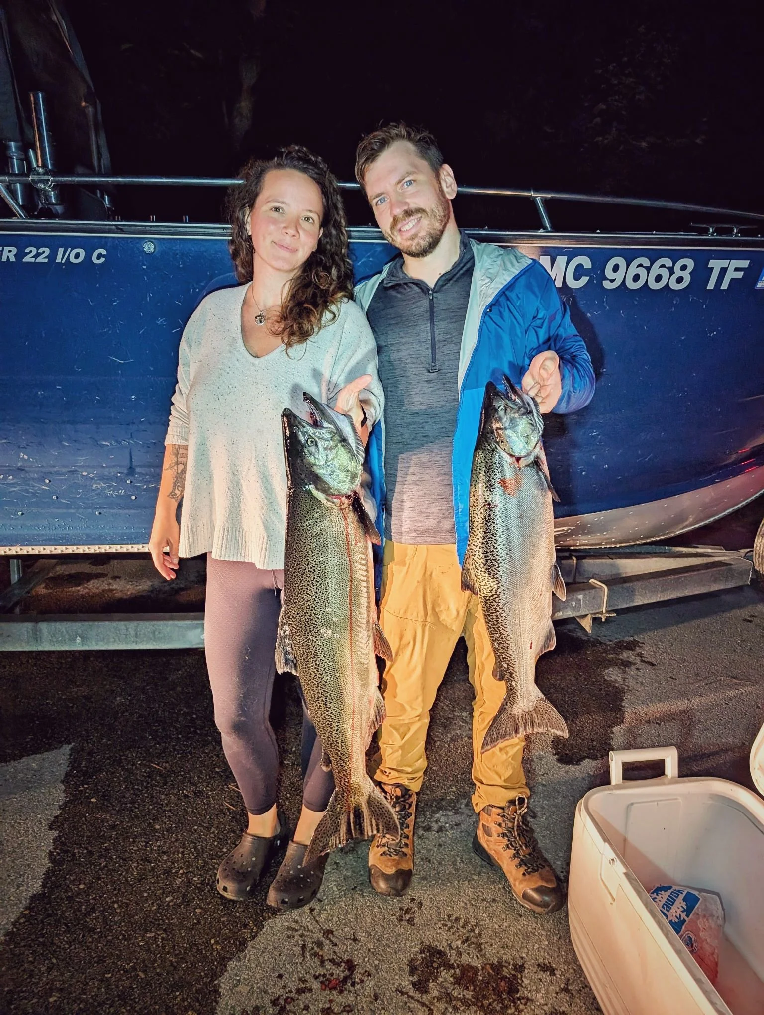 A couple showcasing their trophy Kings caught during a sunrise salmon charter on the beautiful waters of Grand Traverse Bay.