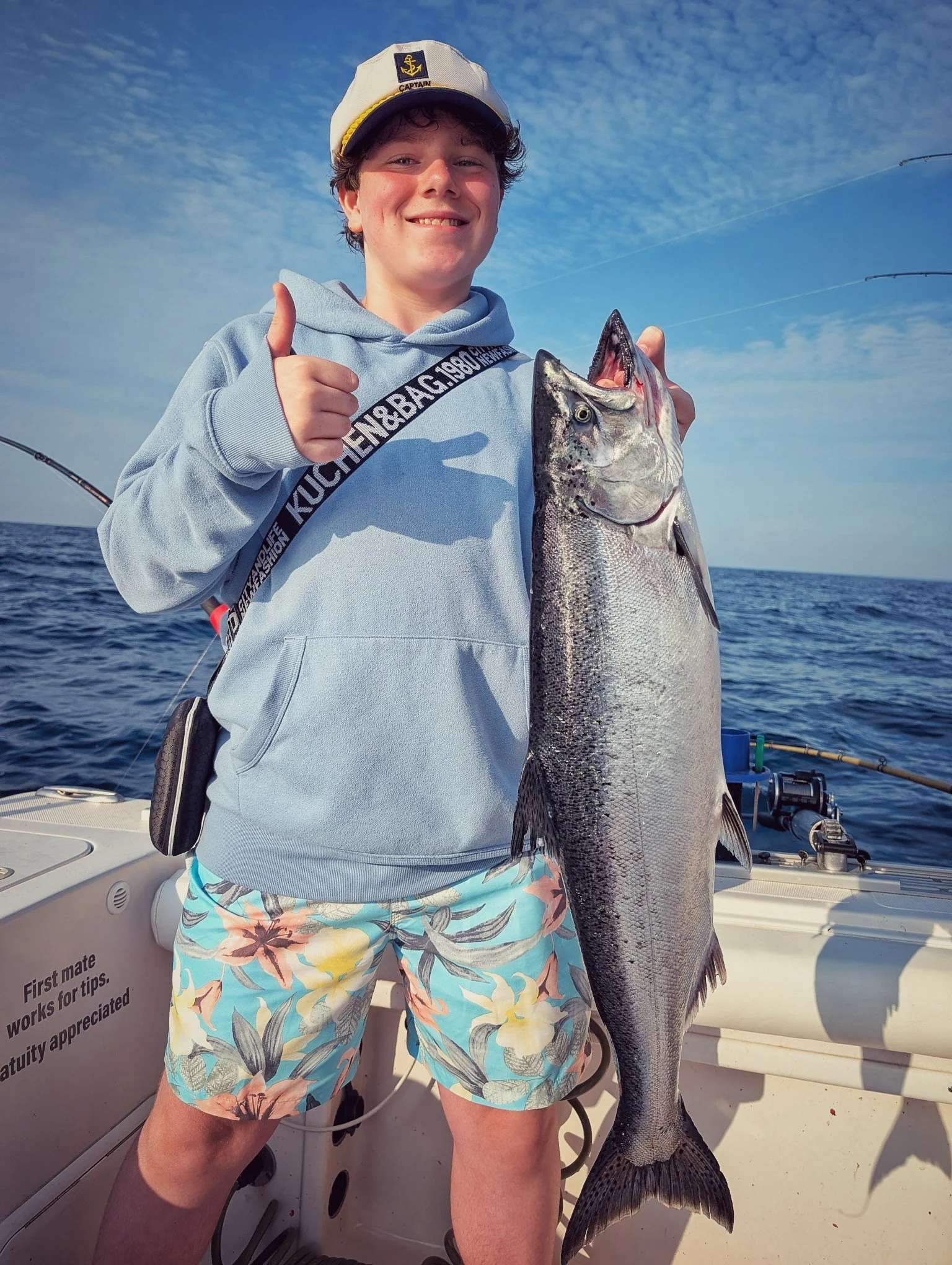 A young fisherman giving a thumbs up while holding a large King Salmon caught on Lake Huron during a Reel Fish'n charter out of Oscoda, MI. 