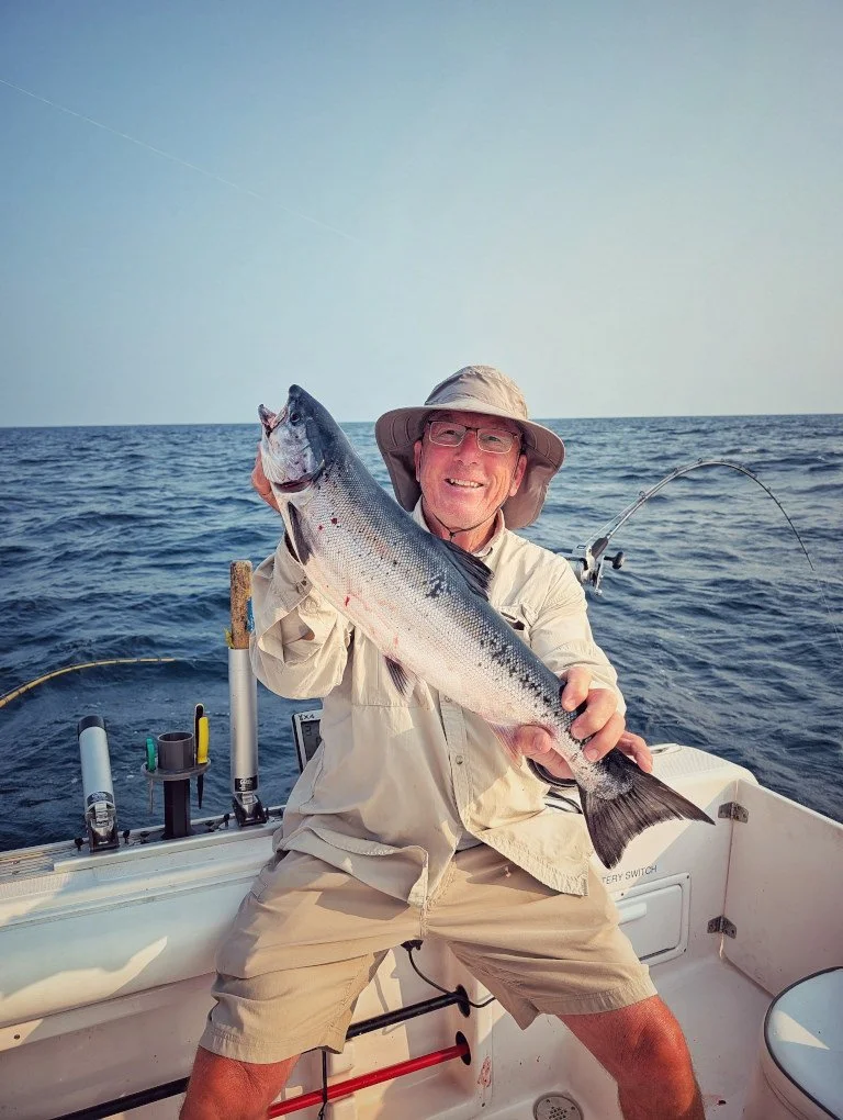 A trophy-sized Atlantic Salmon being showcased by an angler on the deck of a professional Reel Fish'n LLC charter boat on Lake Huron. 