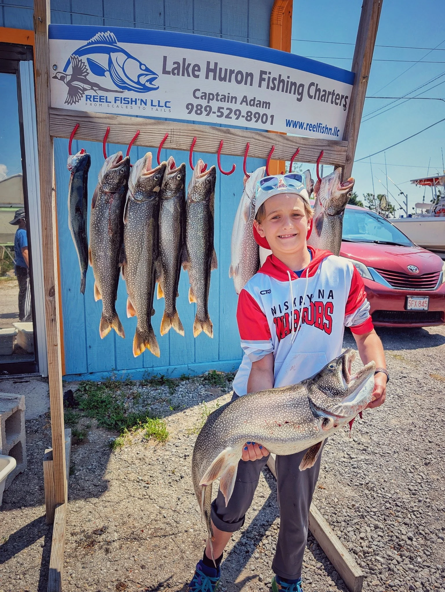  A young angler posing with a full hanging rack of Lake Huron salmon and trout at the Reel Fish'n weigh-in station in Oscoda. 