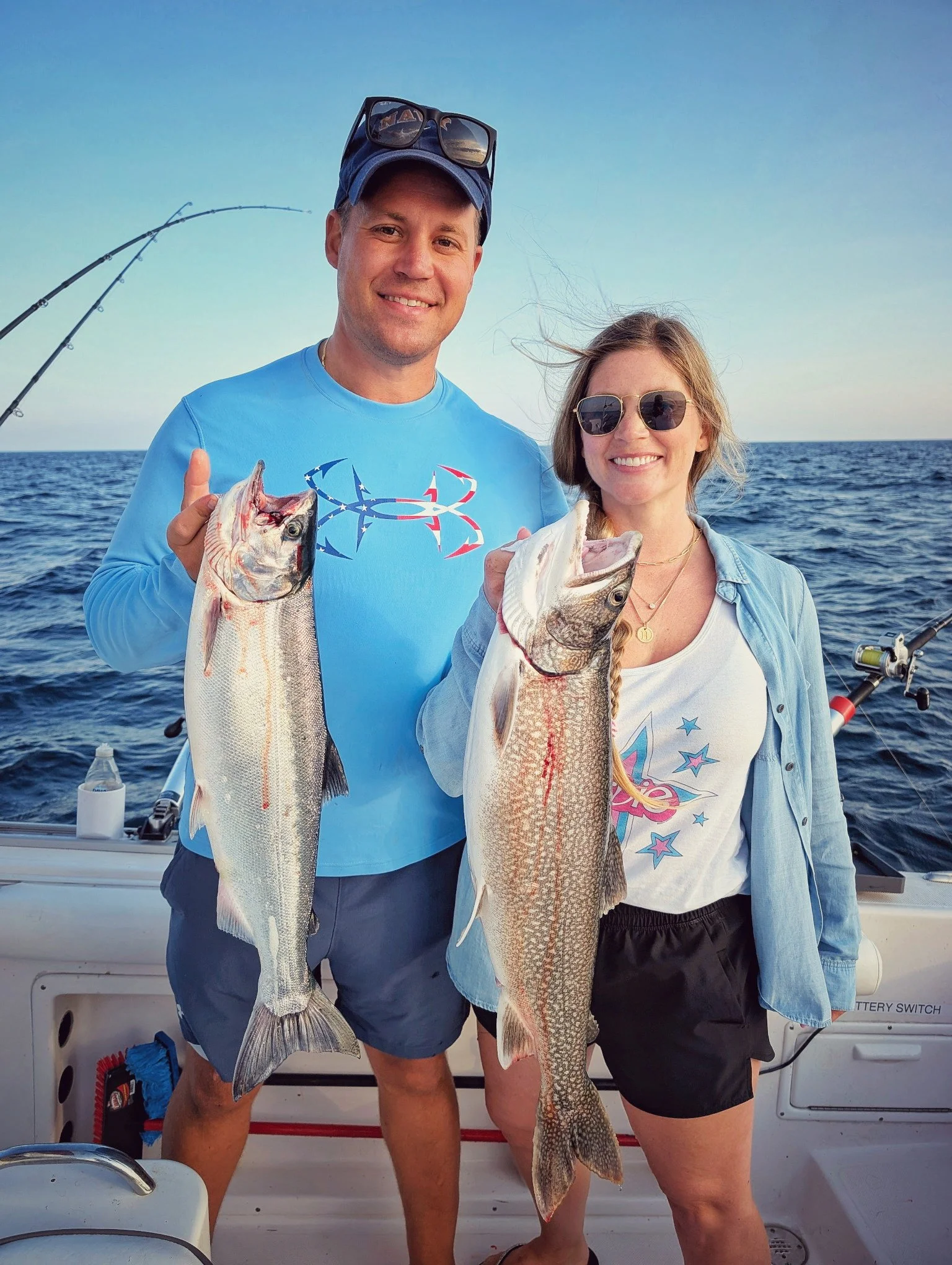  A happy couple showcasing a mixed catch of Steelhead and Lake Trout on a professional Lake Huron fishing charter with Reel Fish'n in Oscoda, Michigan. 
