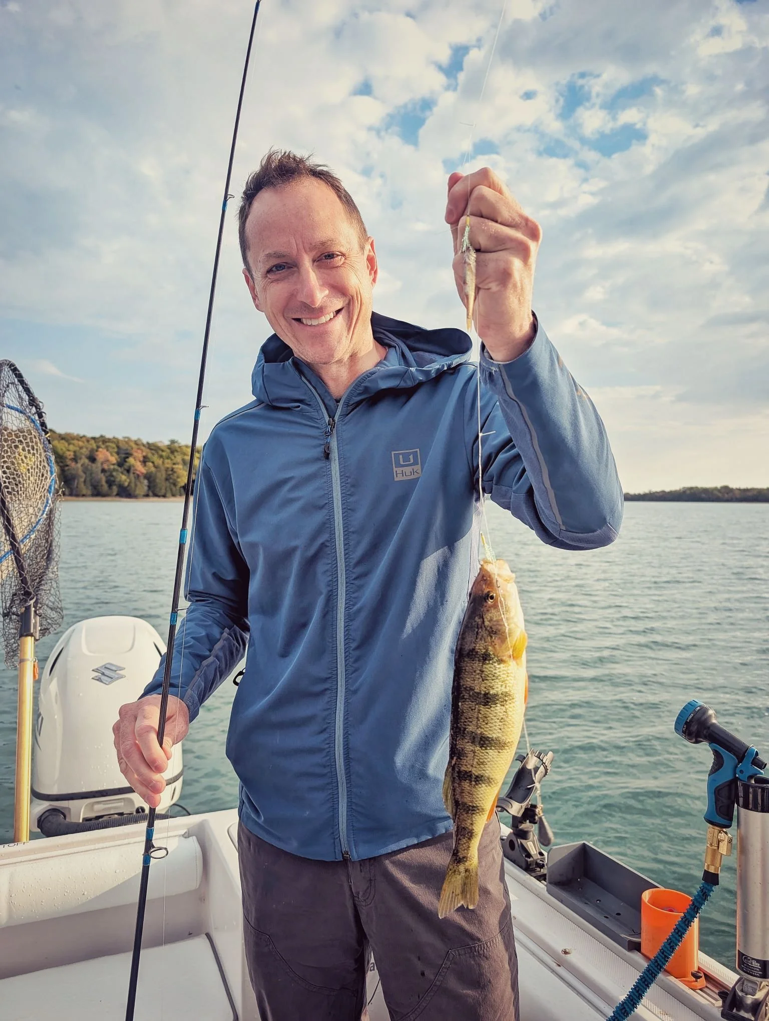  A happy angler holding up a fresh yellow perch caught during a fall fishing trip on Drummond Island with Reel Fish'n.   