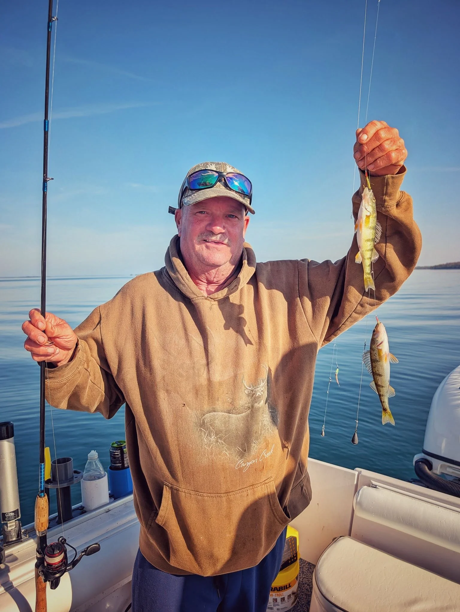  An angler showcasing a double header of yellow perch caught on a spreader rig during a calm October morning on Drummond Island with Reel Fish'n. 