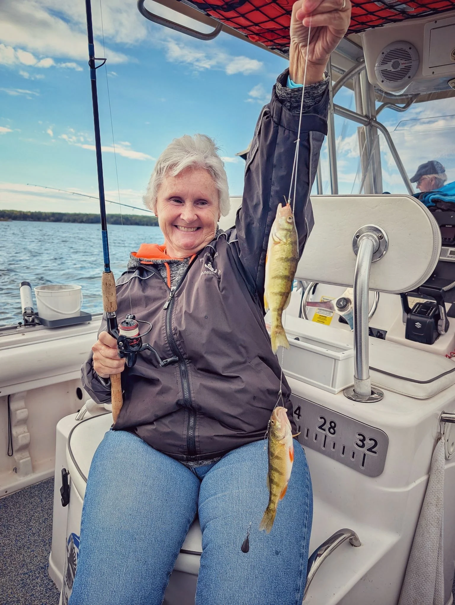  A female angler holding a double header of yellow perch caught during a fall trip on Drummond Island, launching from Drummond Island Yacht Haven with Reel Fish'n. 