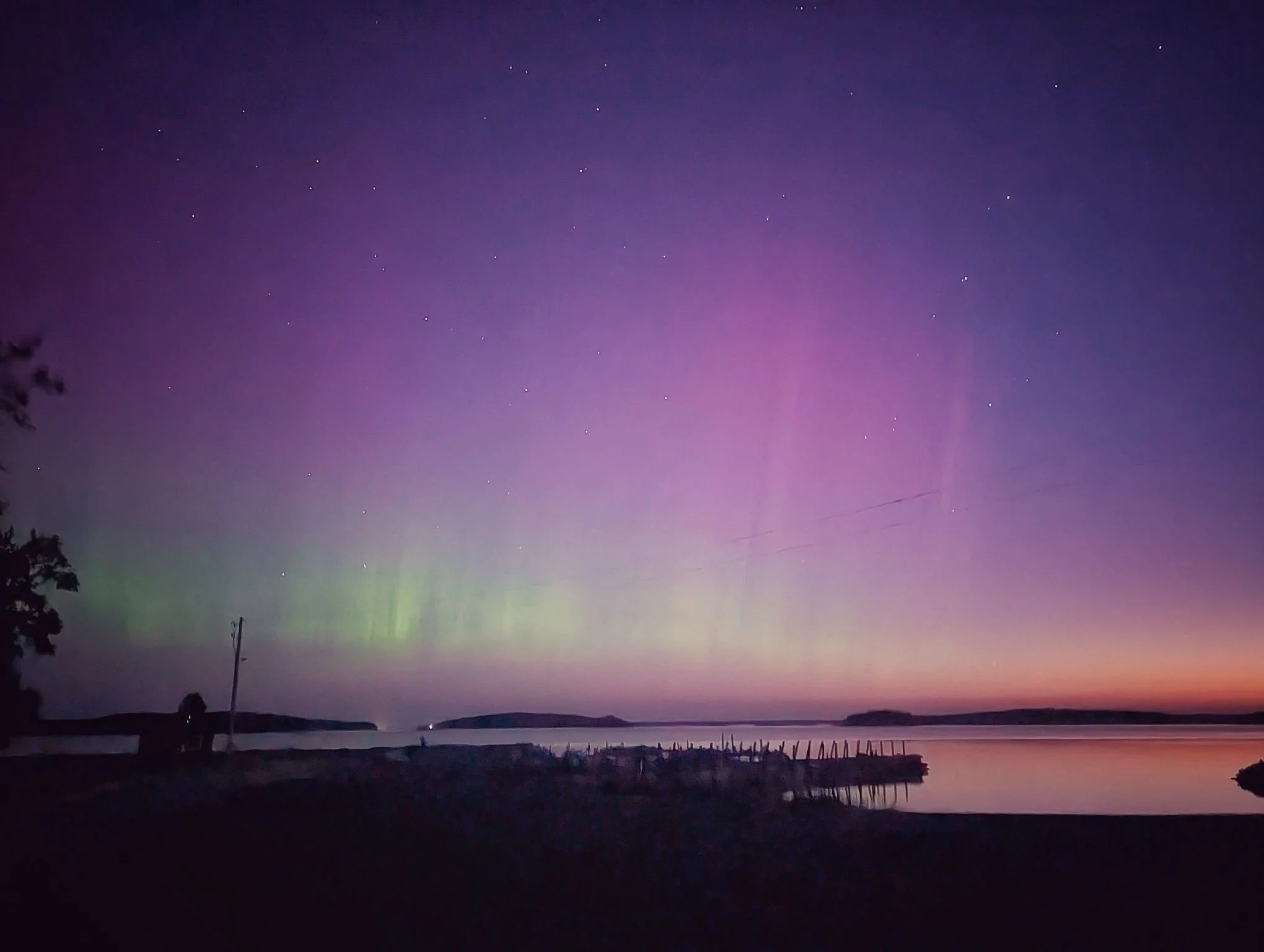  The Northern Lights (Aurora Borealis) glowing over the dark skies of Drummond Island, Michigan, during a crisp fall night in October.   