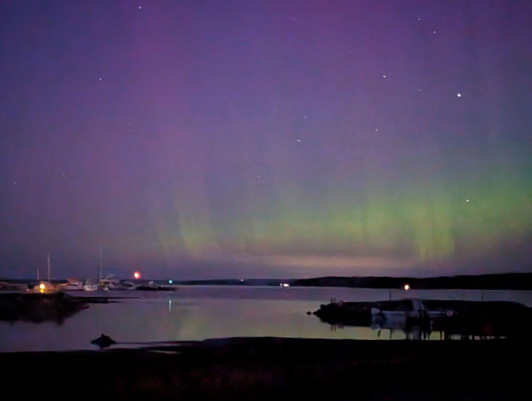  The Northern Lights (Aurora Borealis) illuminating the night sky over the harbor at Drummond Island Yacht Haven during a clear October night.   