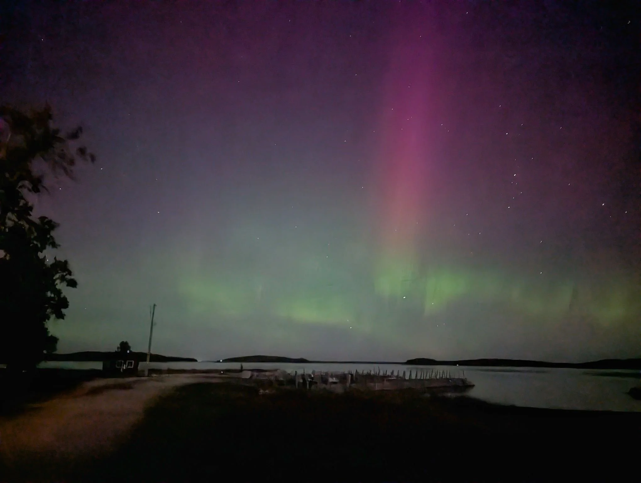  A spectacular display of pink and green Northern Lights (Aurora Borealis) over the dark skies of Drummond Island, Michigan, during a clear October night.   