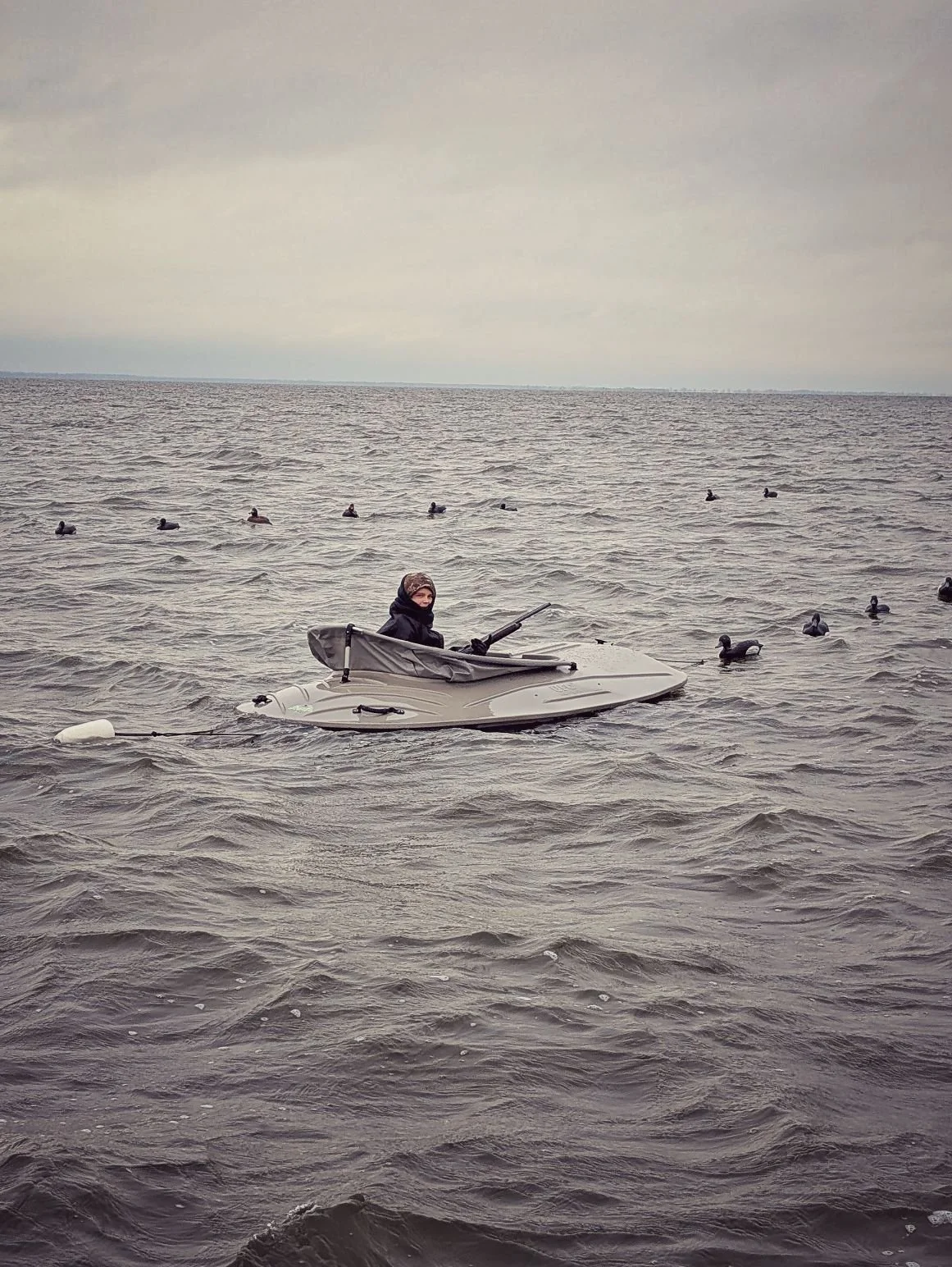 An angler positioned in a UFO layout boat amidst a spread of sea duck decoys, targeting longtails and scoters on Saginaw Bay.   
