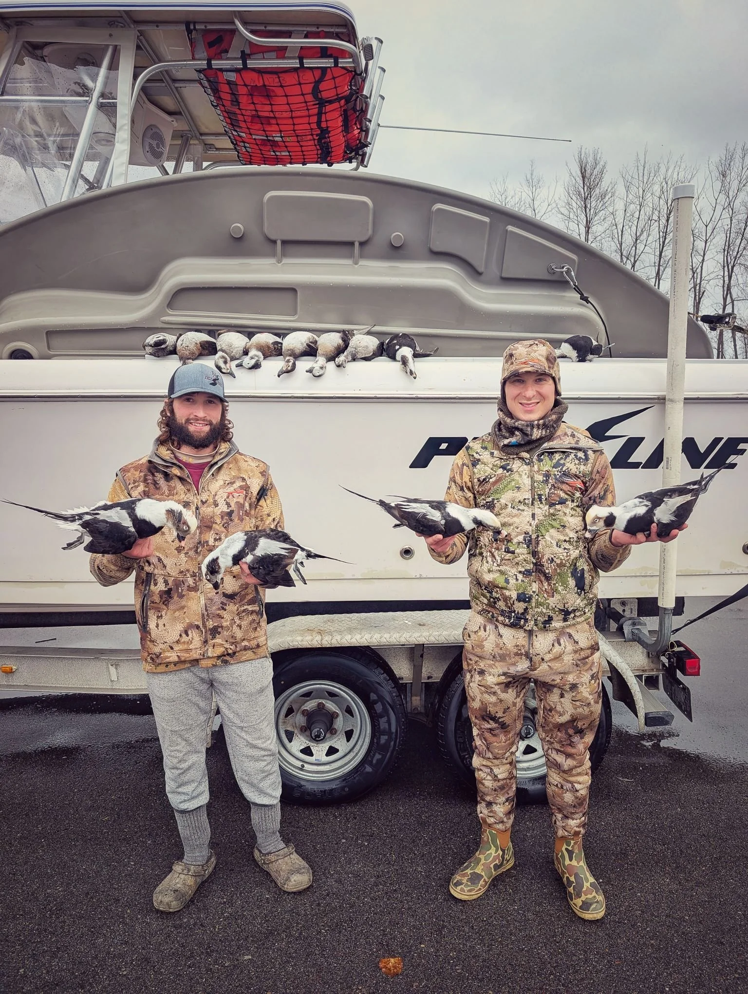  Two successful hunters holding trophy Longtails (Long-tailed ducks / Old Squaw) in front of the Proline tender boat after a morning in the layout boats.   