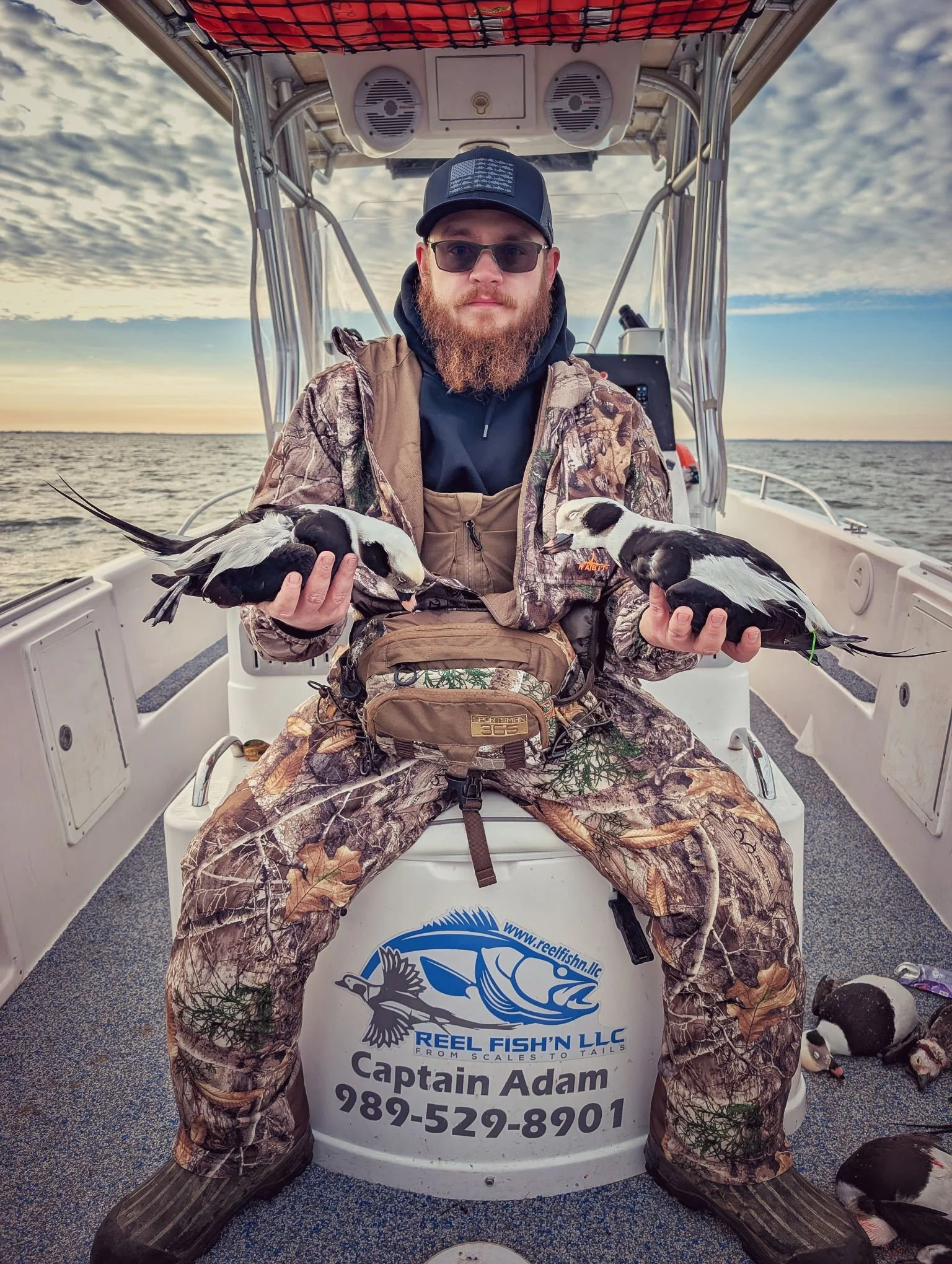  A successful sea duck hunter holding a pair of mature Longtails (Long-tailed duck / Old Squaw) harvested during an open-water layout hunt with Reel Fish'n.   