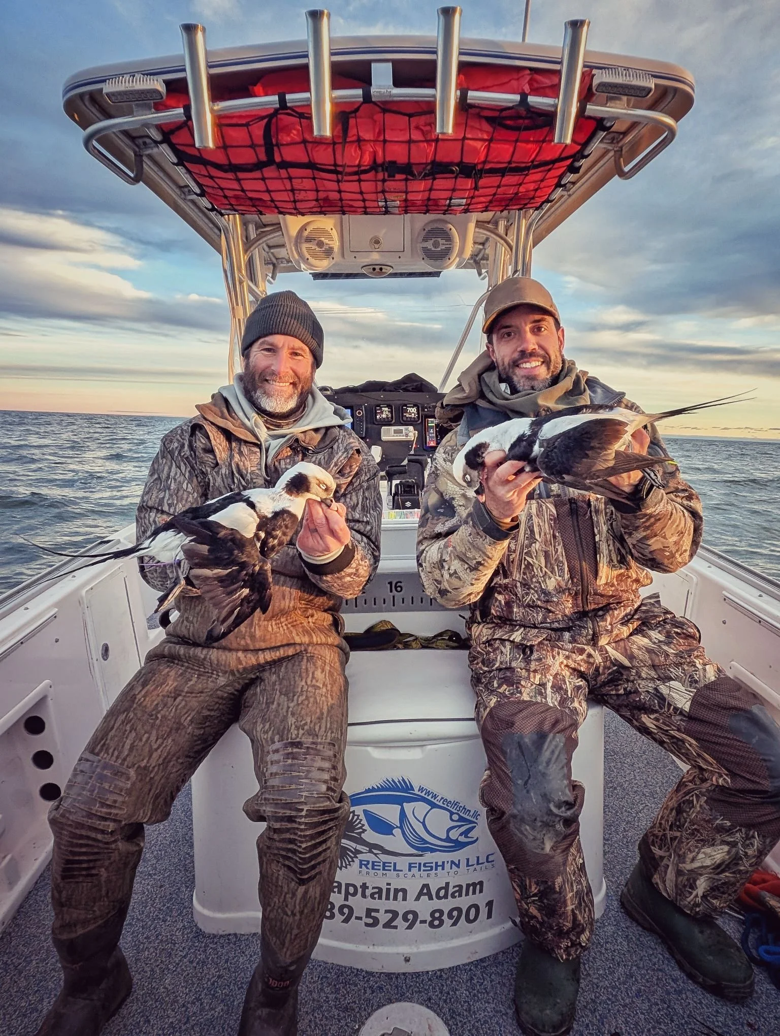  Two successful hunters displaying a brace of mature Longtails (Long-tailed ducks) shot during an open-water layout hunt on the Great Lakes with Reel Fish'n.   