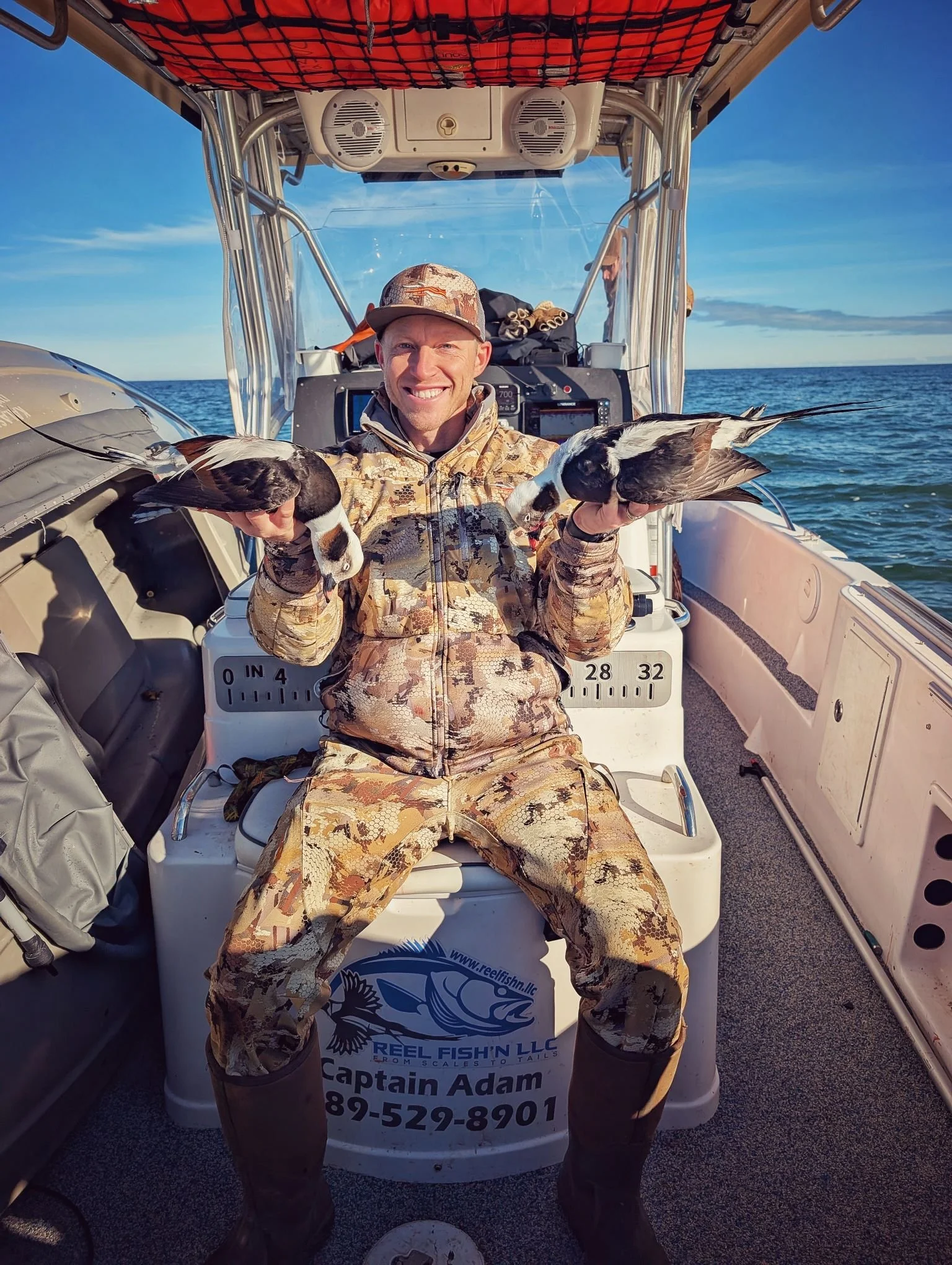  A hunter showcasing a diverse bag of sea ducks harvested during a specialized open-water layout hunt with Reel Fish'n LLC. 