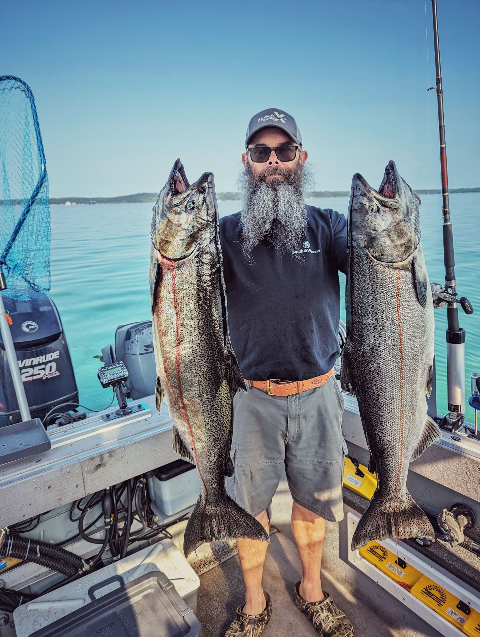  A successful angler holding a massive pair of King Salmon (Chinook) caught during the peak late-summer season on Grand Traverse Bay with Reel Fish'n.   