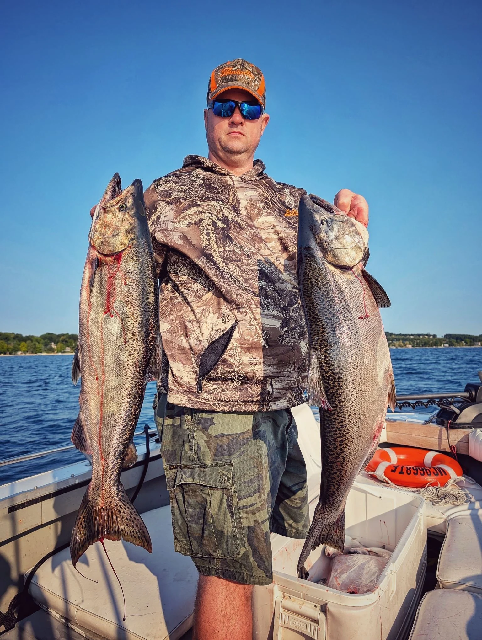  A successful angler holding a pair of mature King Salmon (Chinook) caught during a late-summer charter on Grand Traverse Bay with Reel Fish'n.   