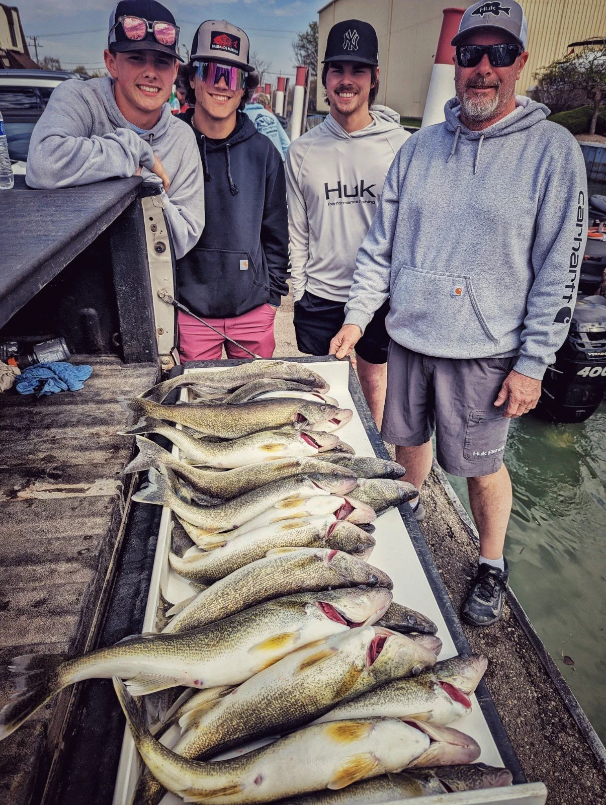  A group of four men posing behind a heavy limit of Detroit River walleye displayed on a truck tailgate after a Reel Fish'n charter trip. 