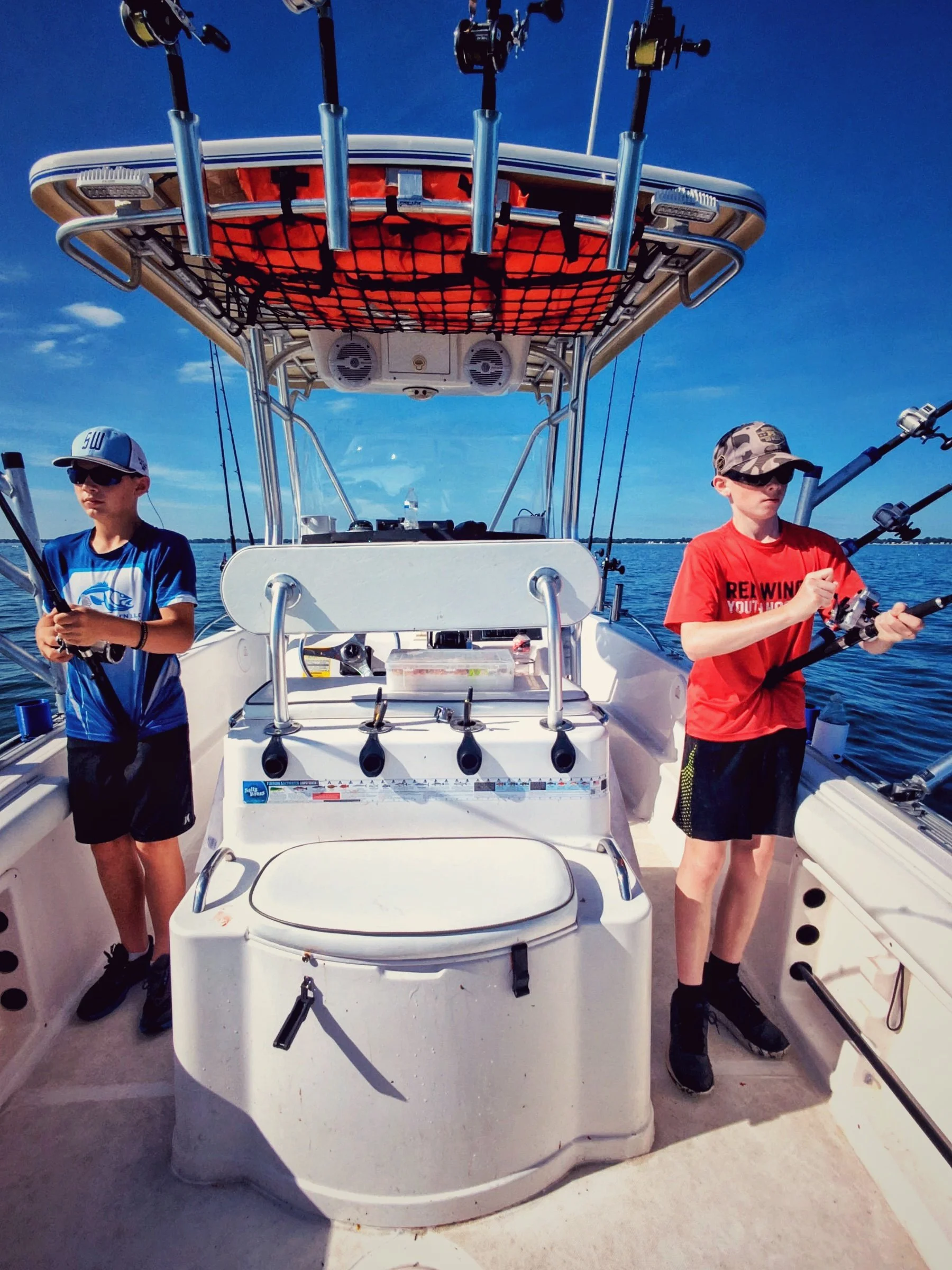  Two young boys managing the rods while trolling for walleye on the open waters of Saginaw Bay aboard the Reel Fish'n 25ft Proline center console. 