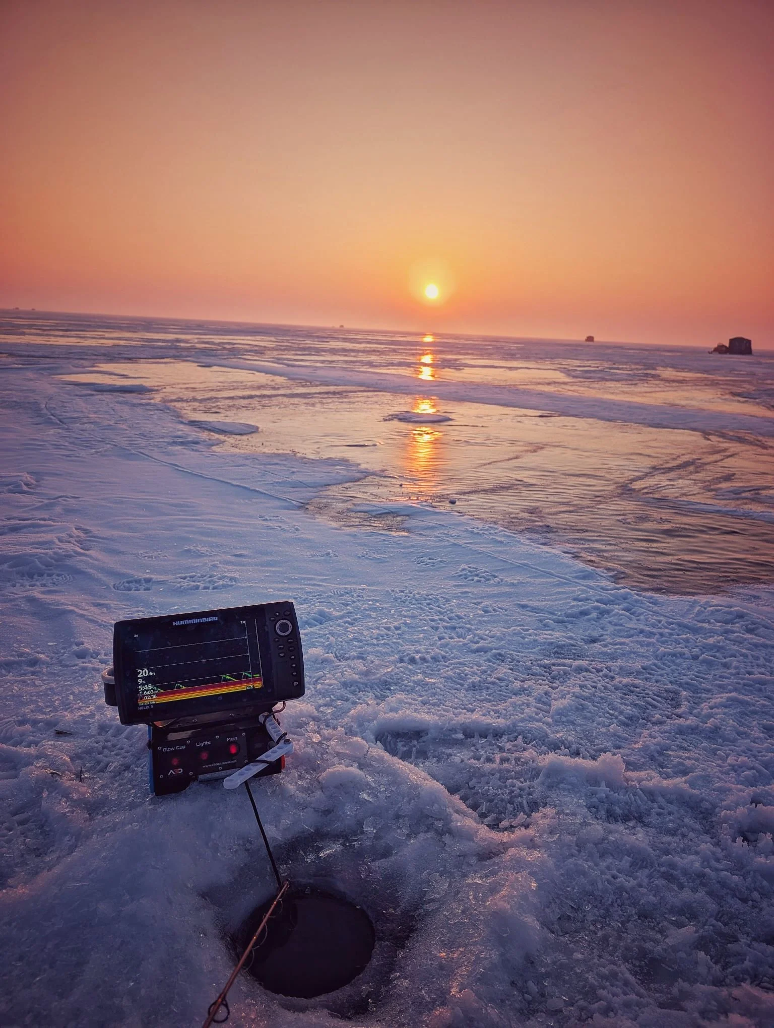  A stunning winter sunset over the ice on Saginaw Bay, featuring a professional sonar unit ready for an evening walleye bite out of Linwood, MI.   