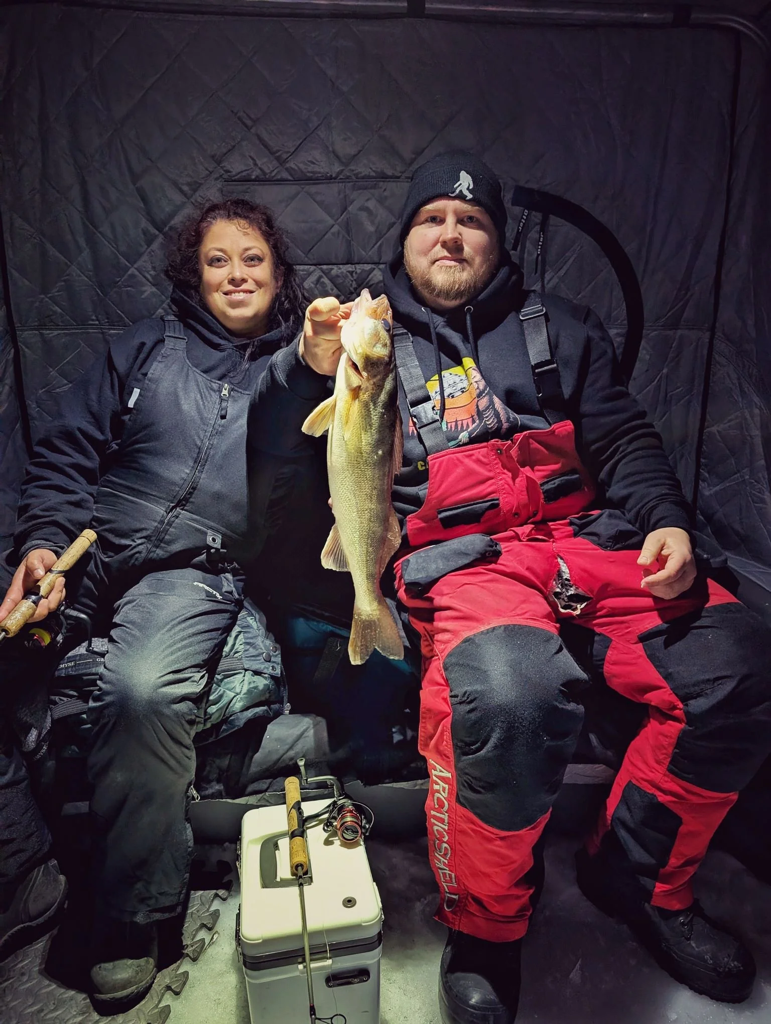  A couple showcasing a nice walleye caught during a guided Saginaw Bay ice fishing trip with Reel Fish'n, operating out of Linwood and Bay City.   